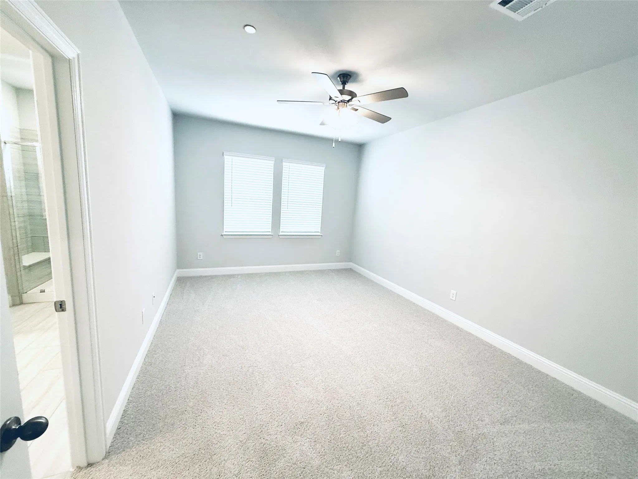 Spacious room with light-toned carpeting and neutral wall tones