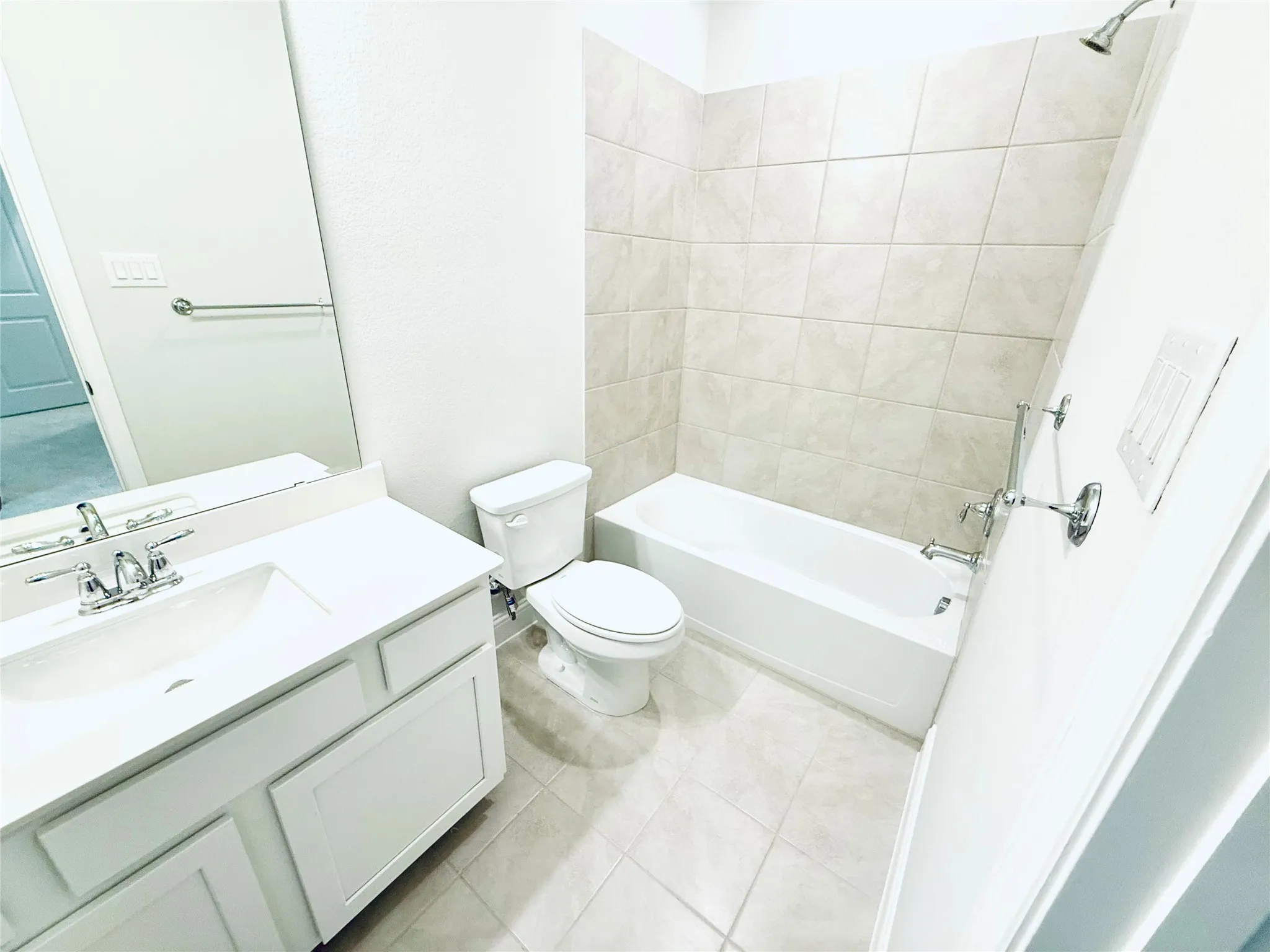 Bathroom featuring a white vanity with an integrated sink, chrome faucet, and rectangular mirror