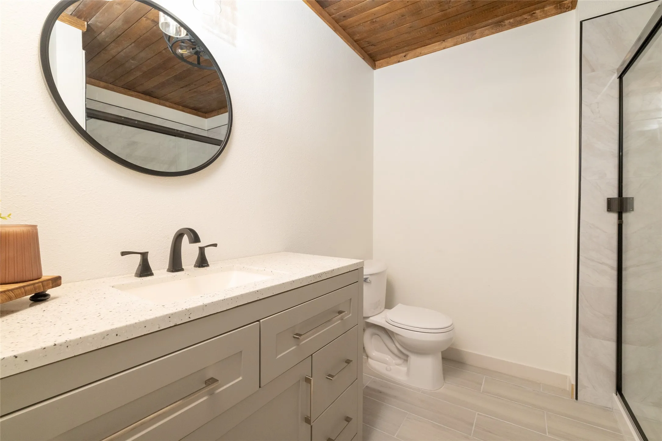 Vaulted wood-finish ceiling accentuates this bathroom's modern design