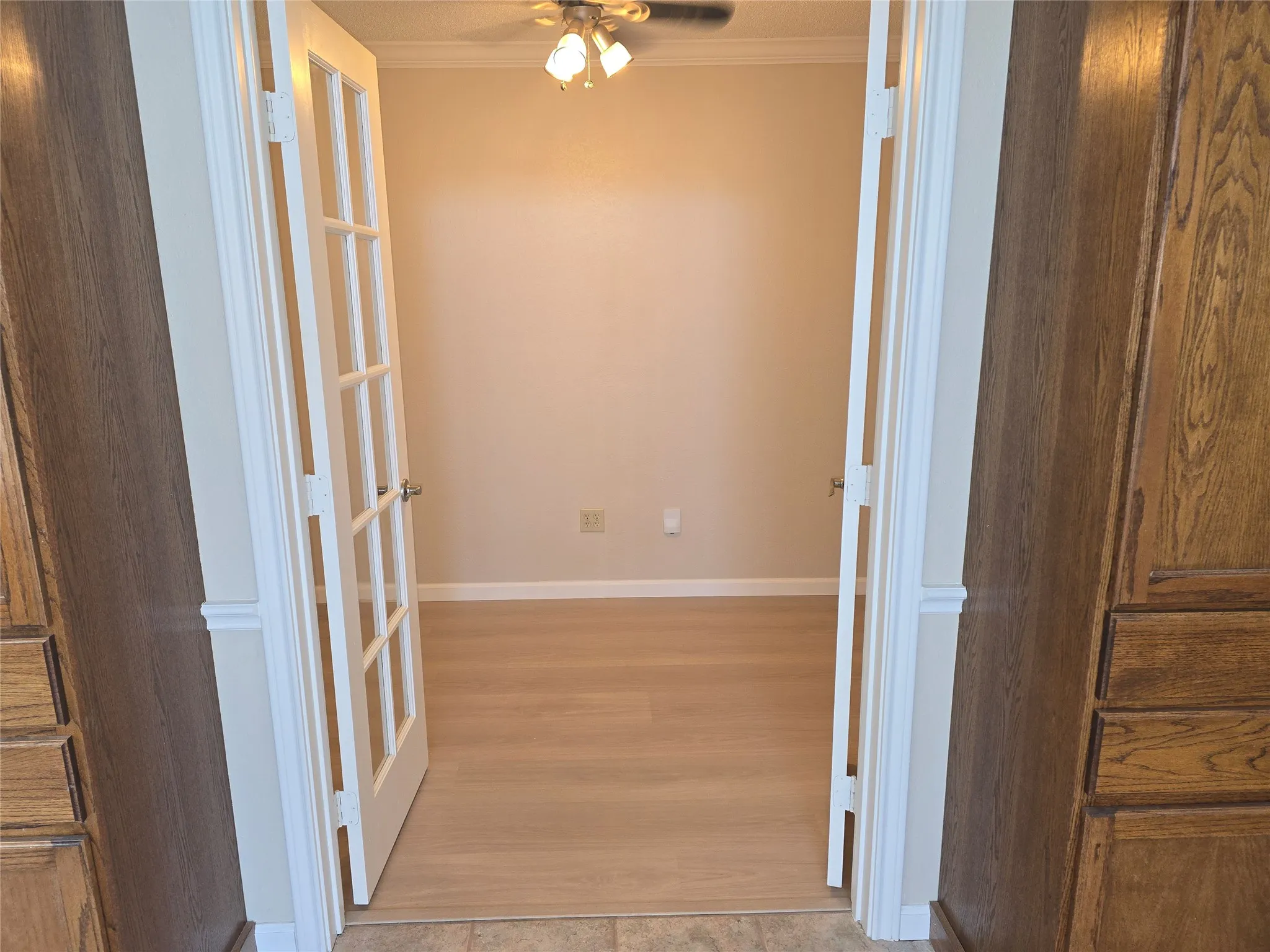 Room featuring light wood-finish flooring, neutral wall paint, and white trim