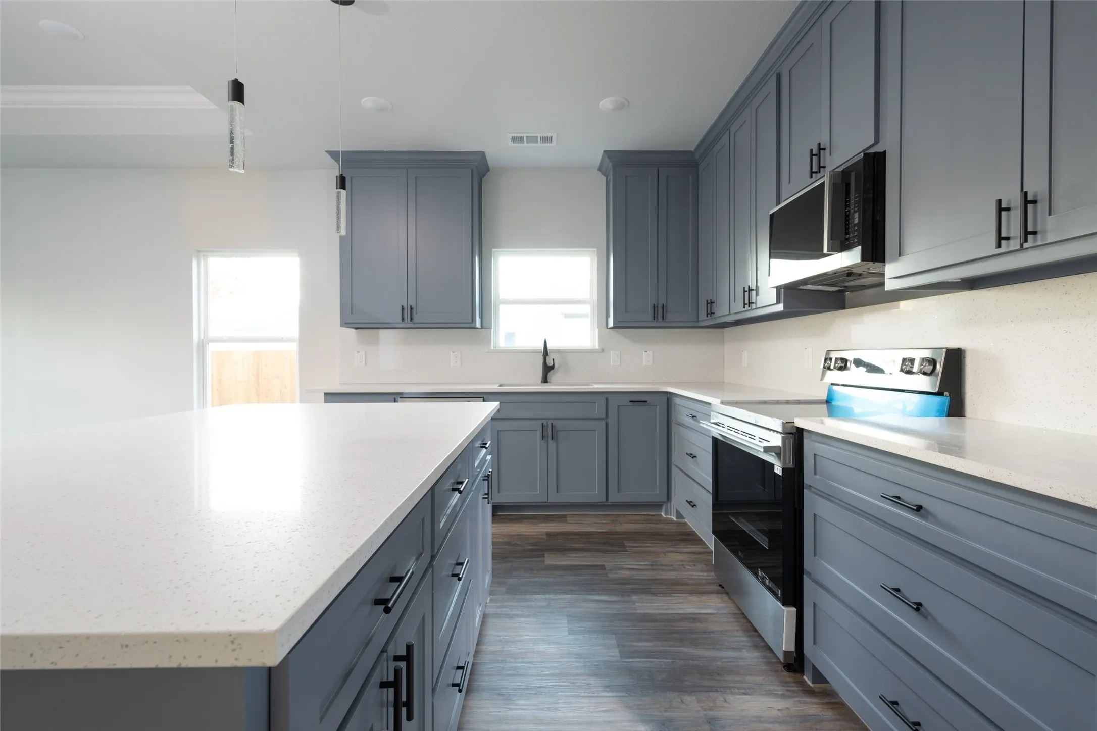 Modern kitchen featuring an expansive center island with a white speckled countertop