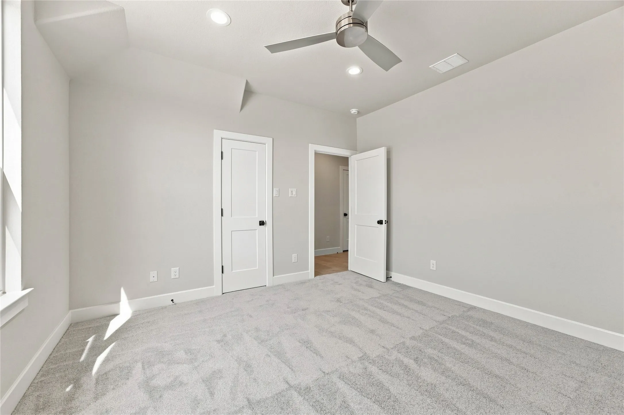 Recessed lighting, ceiling fan, white paneled doors, light grey carpeting, and white trim