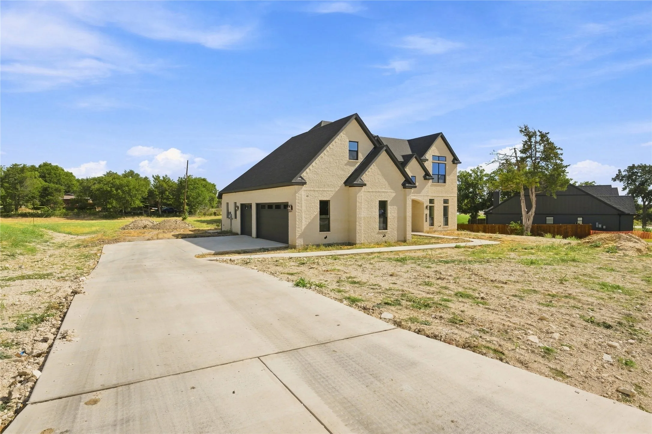 Brick exterior with a dark shingle roof, attached two-car garage, and concrete driveway