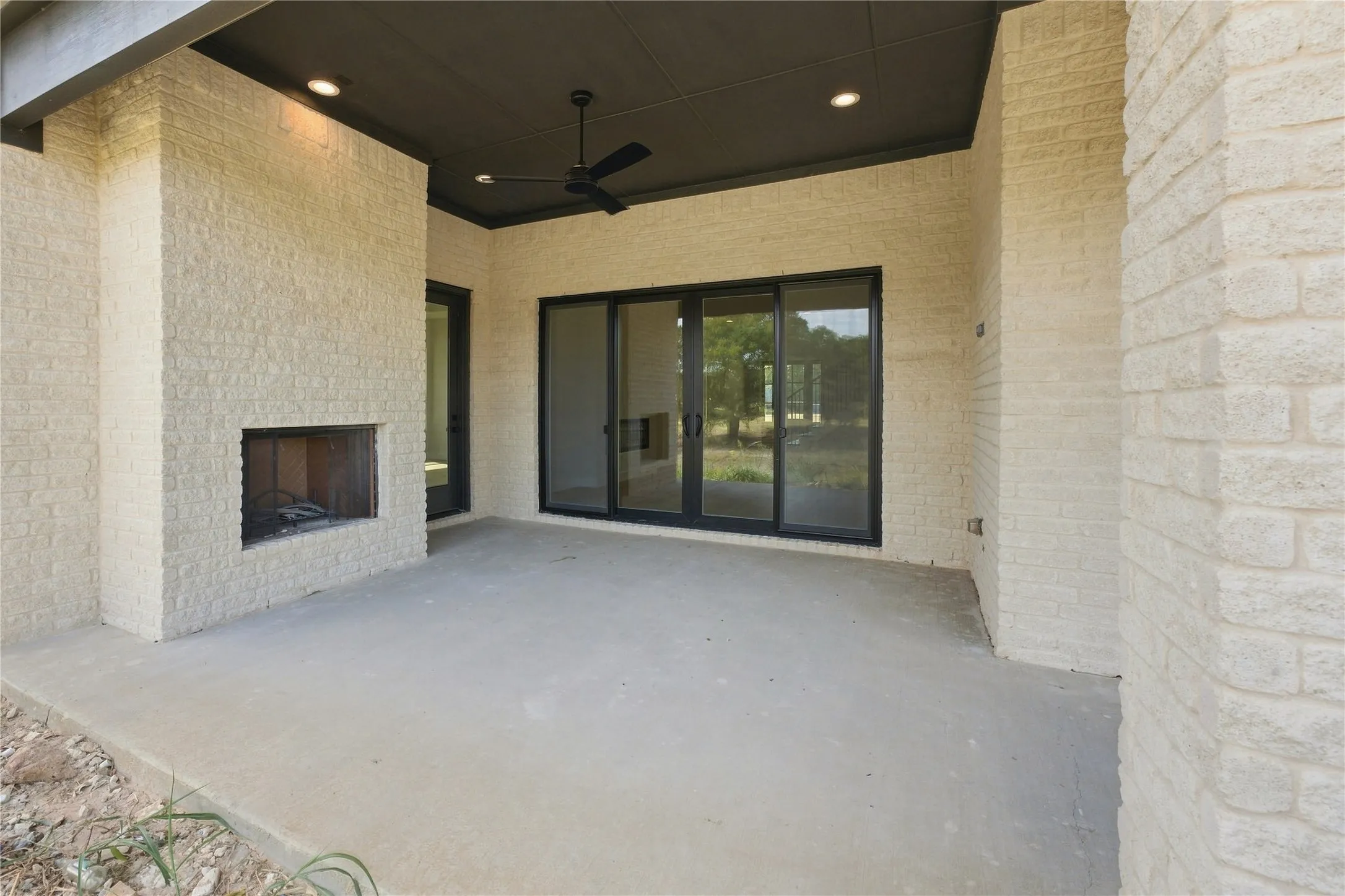 Covered patio featuring an outdoor fireplace, recessed lighting, and a ceiling fan