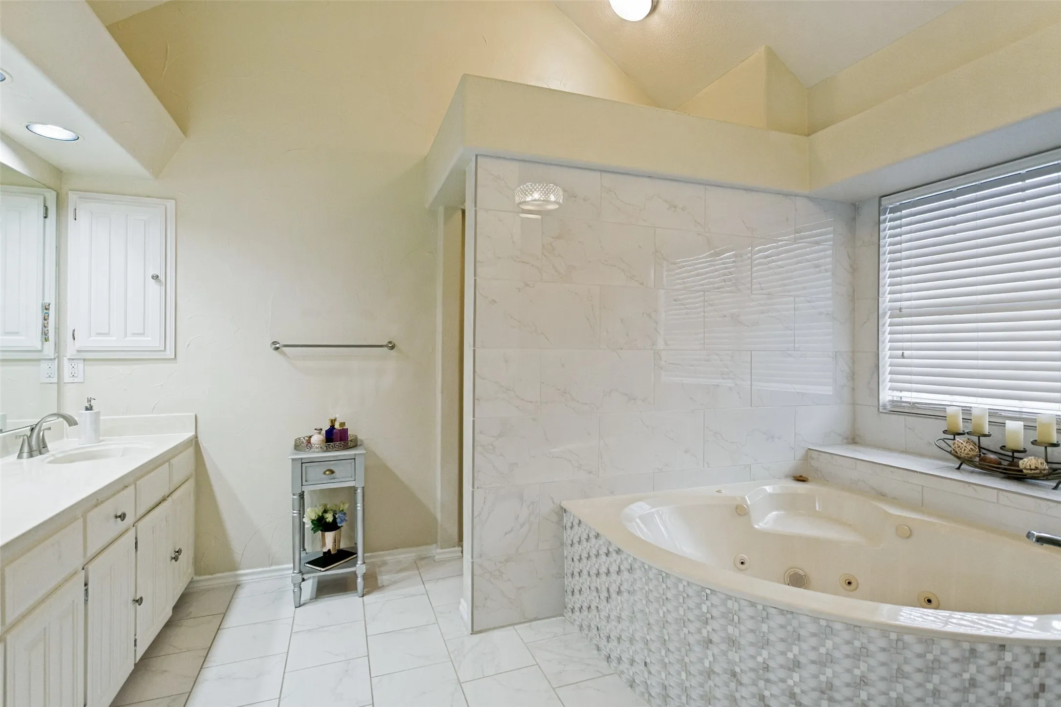 Primary bathroom featuring a soaking tub, separate shower, and dual vanities.