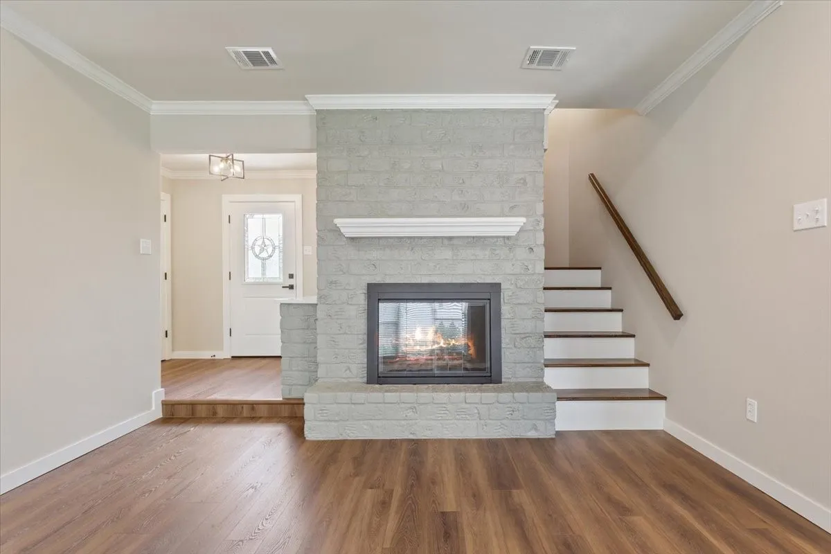 Central fireplace with a painted brick surround, glass doors, and white mantel