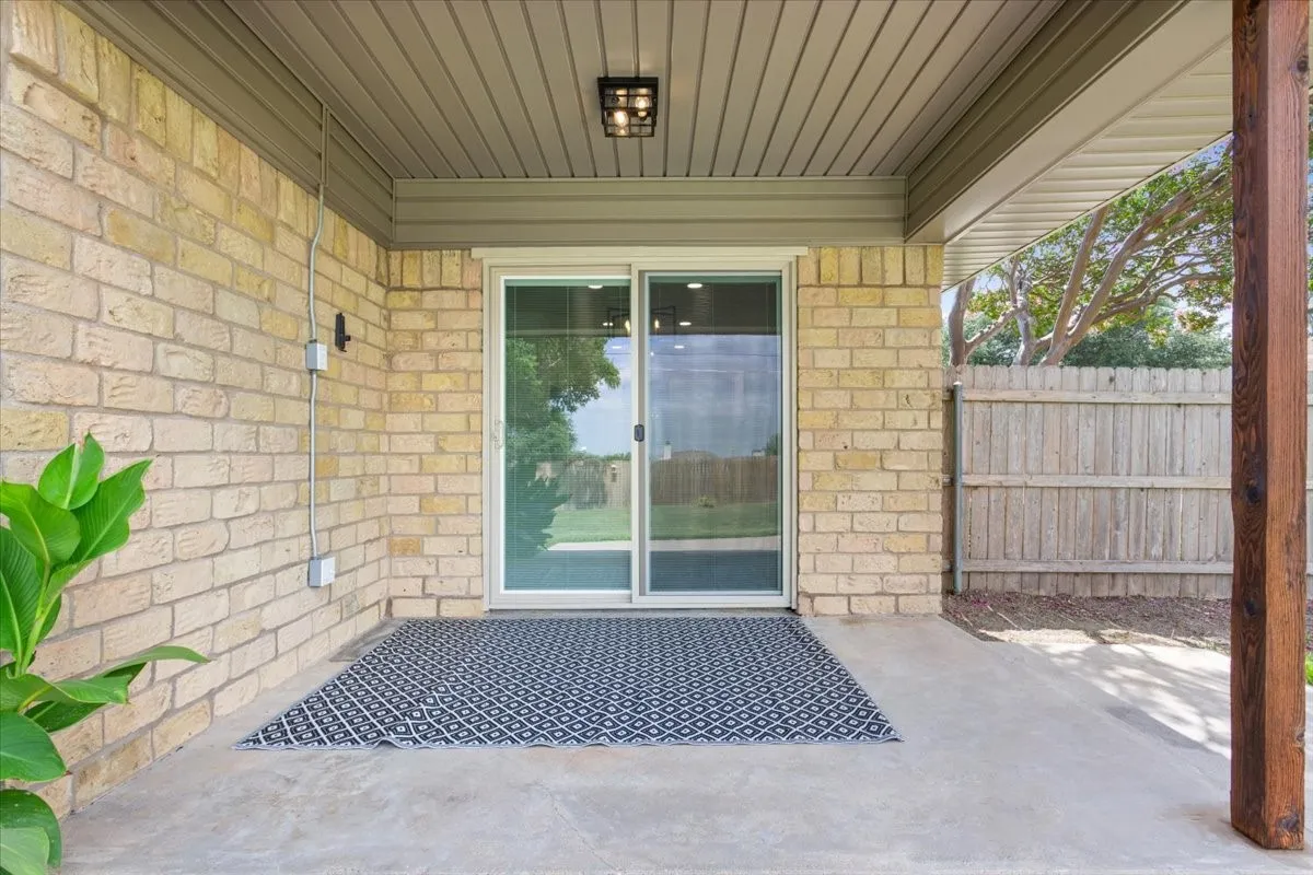Covered back porch with privacy fenced yard