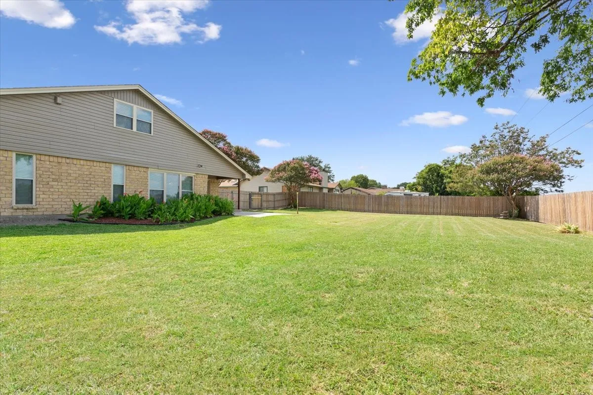 Expansive lawn area with a full privacy fence