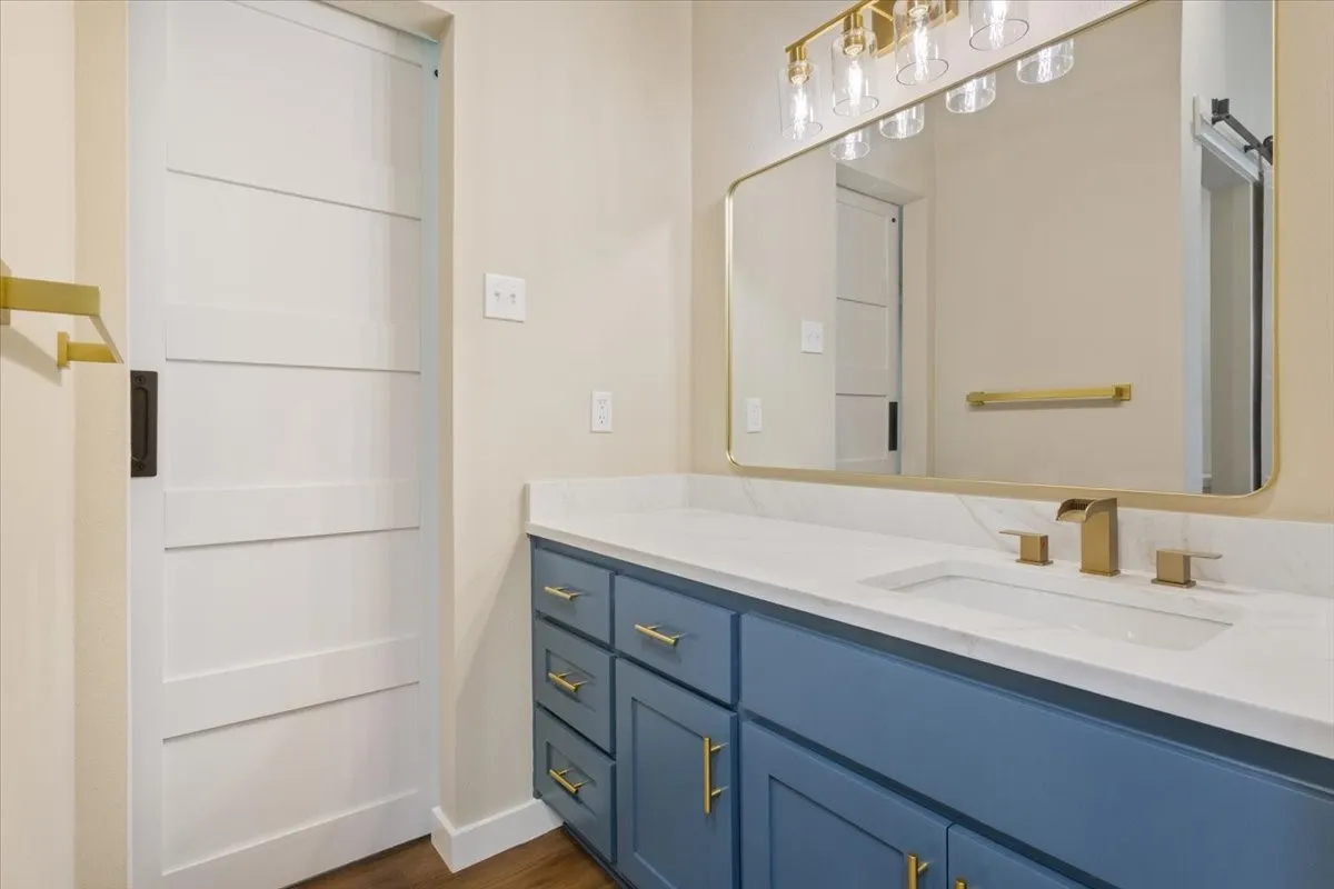 Spacious vanity featuring a waterfall faucet, undermount sink, and quartz countertop