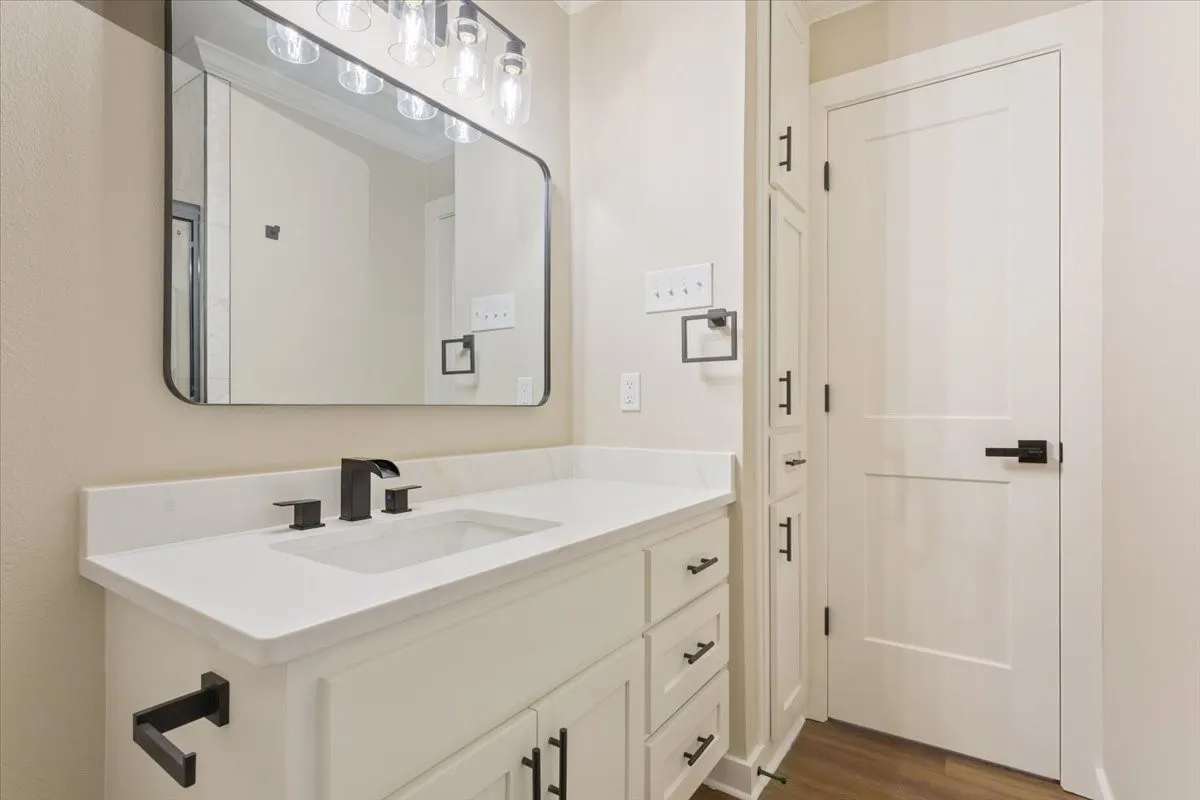 Hall bathroom white quartz vanity featuring a rectangular undermount sink, and matte black faucet