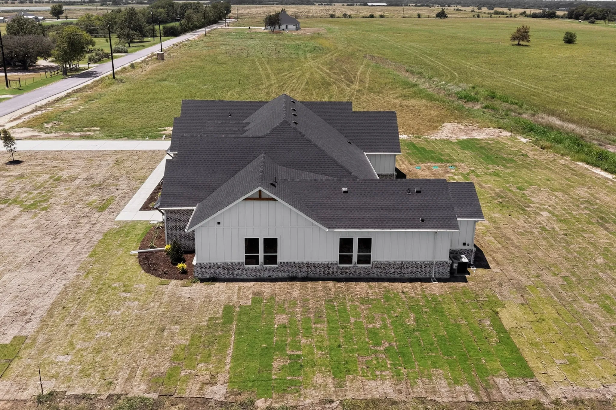 Contemporary single-story residence featuring white vertical siding and a dark shingle roof