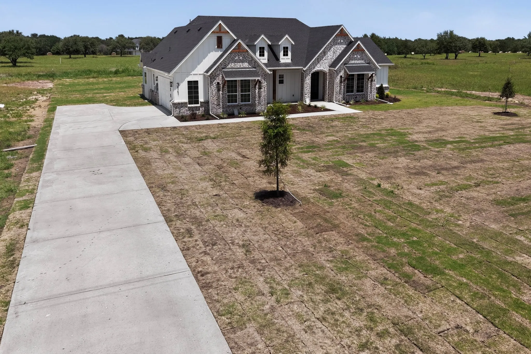 Modern farmhouse exterior featuring white siding and stone accents
