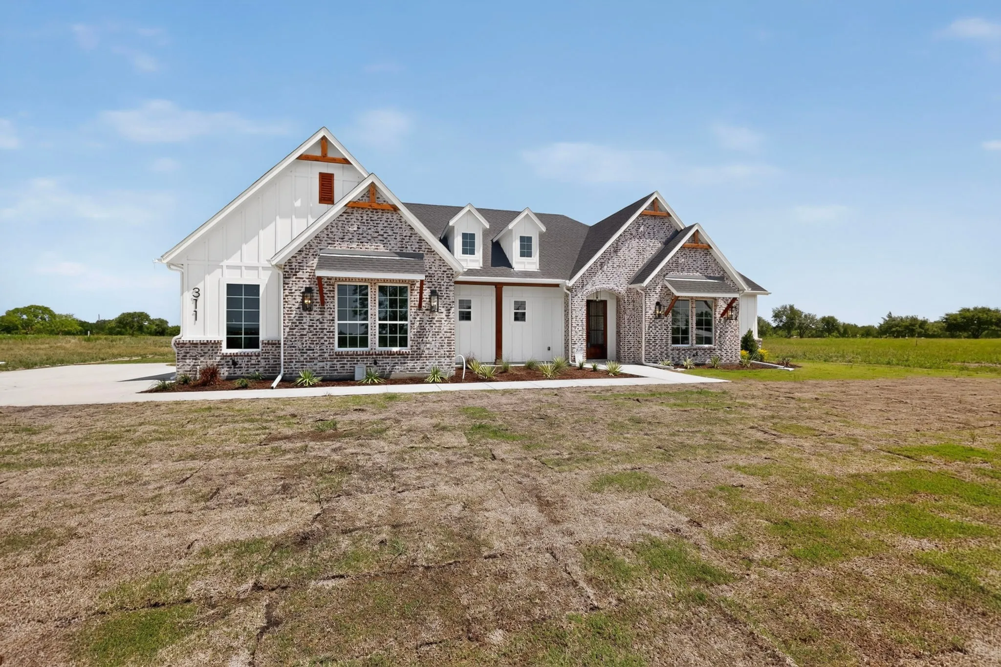 Craftsman-style exterior featuring a combination of white vertical siding and grey brick veneer