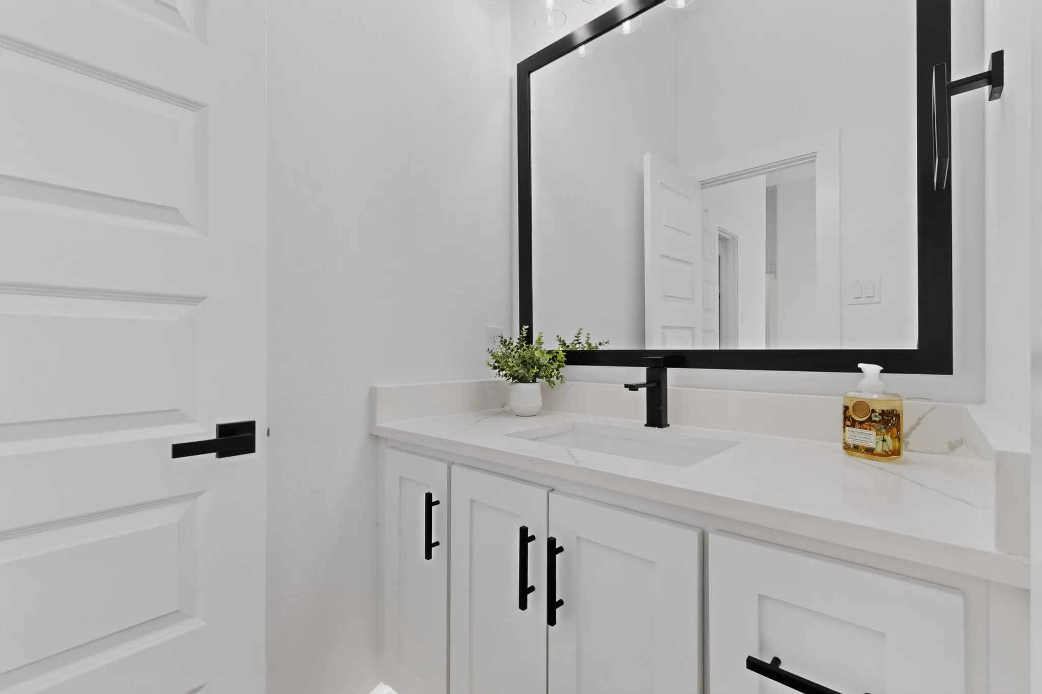 Modern vanity with an integrated rectangular sink, white countertop, and matte black faucet