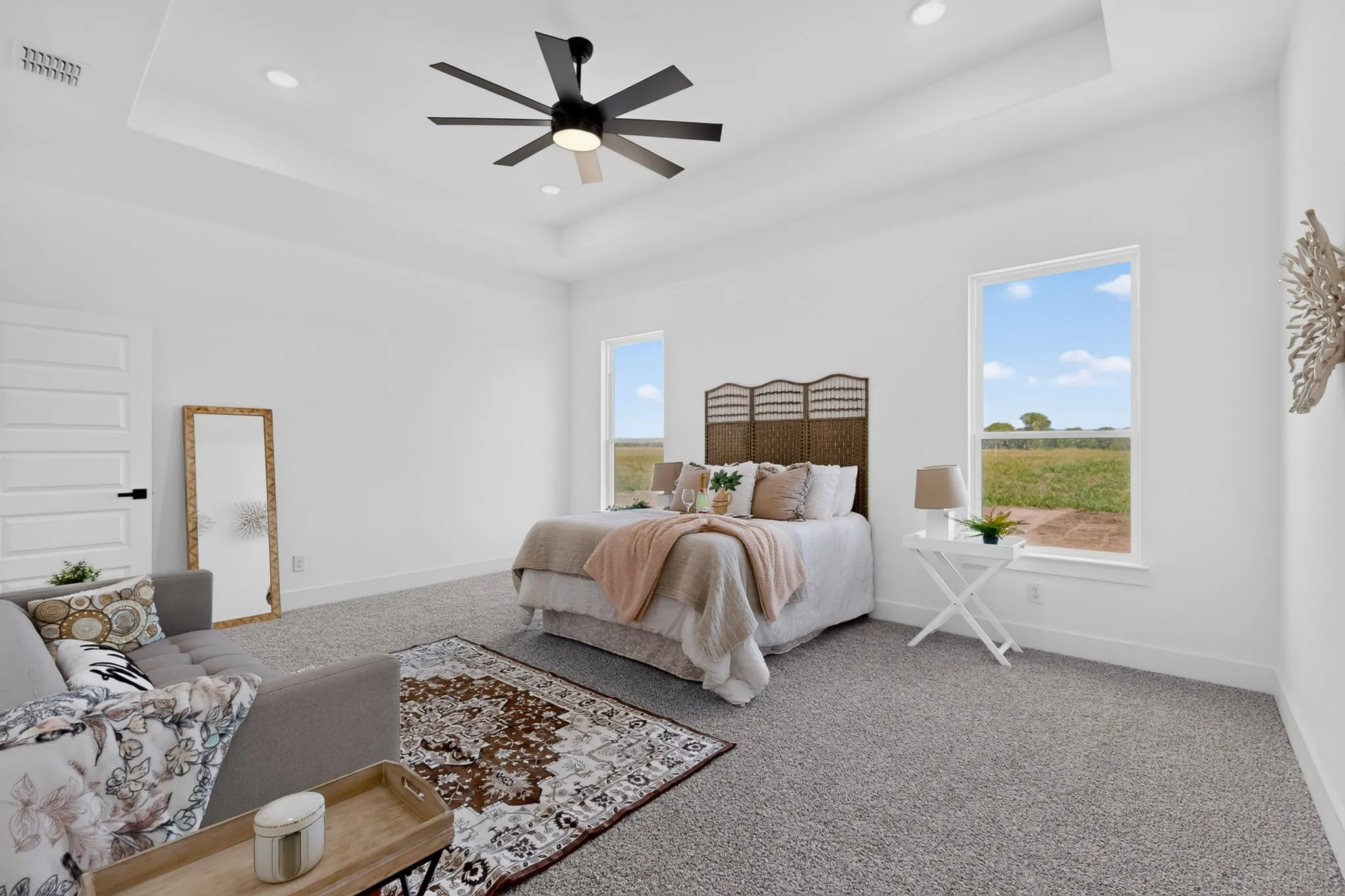 Spacious room featuring a tray ceiling, recessed lighting, and a contemporary ceiling fan