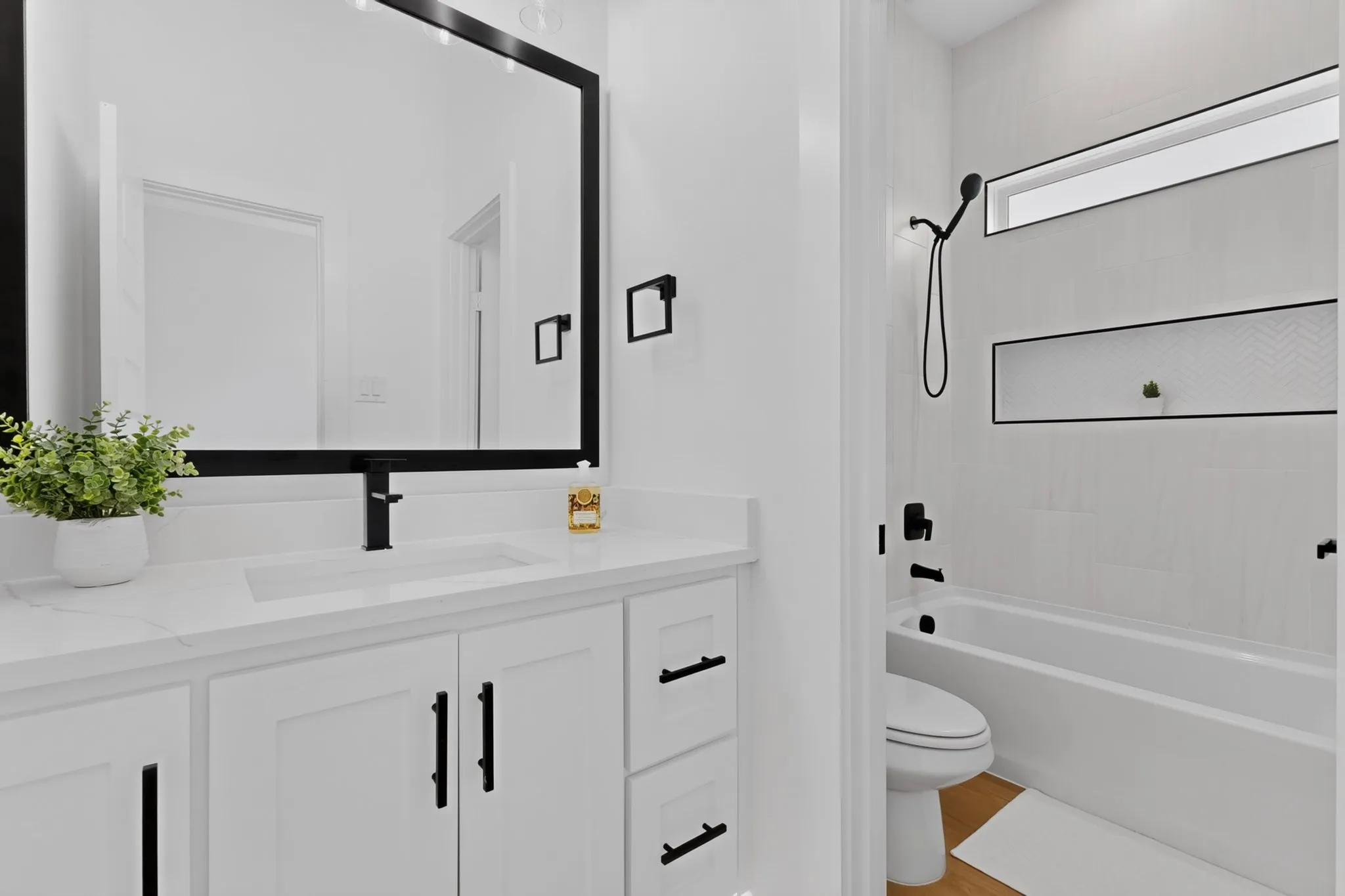 White vanity with an integrated sink, quartz countertop, and matte black faucet