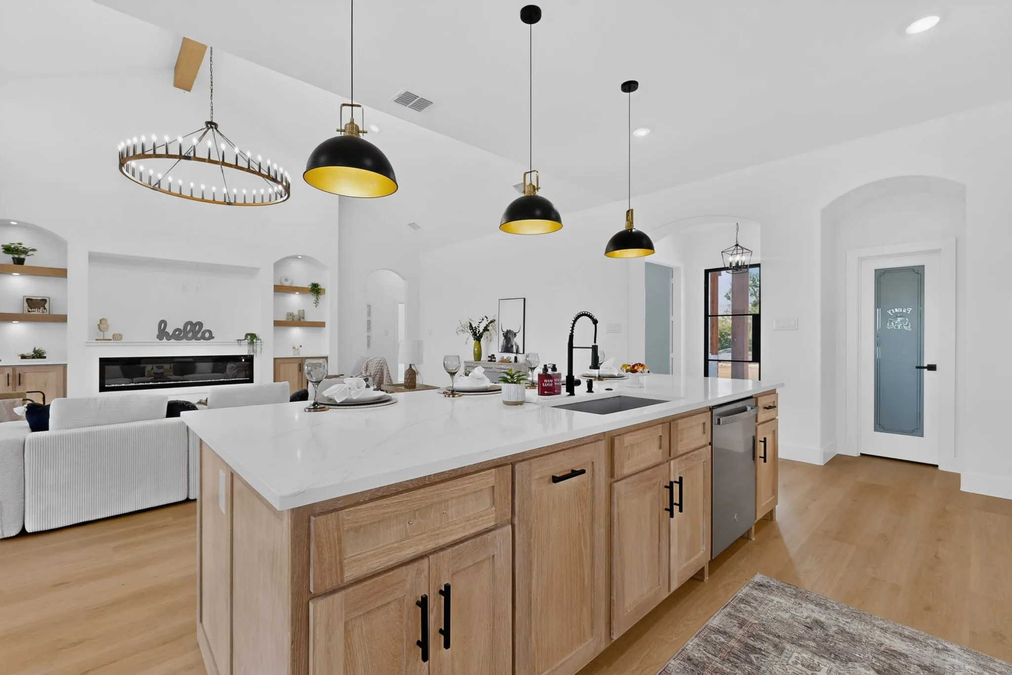 Kitchen island featuring a white countertop, undermount sink, and stainless steel dishwasher