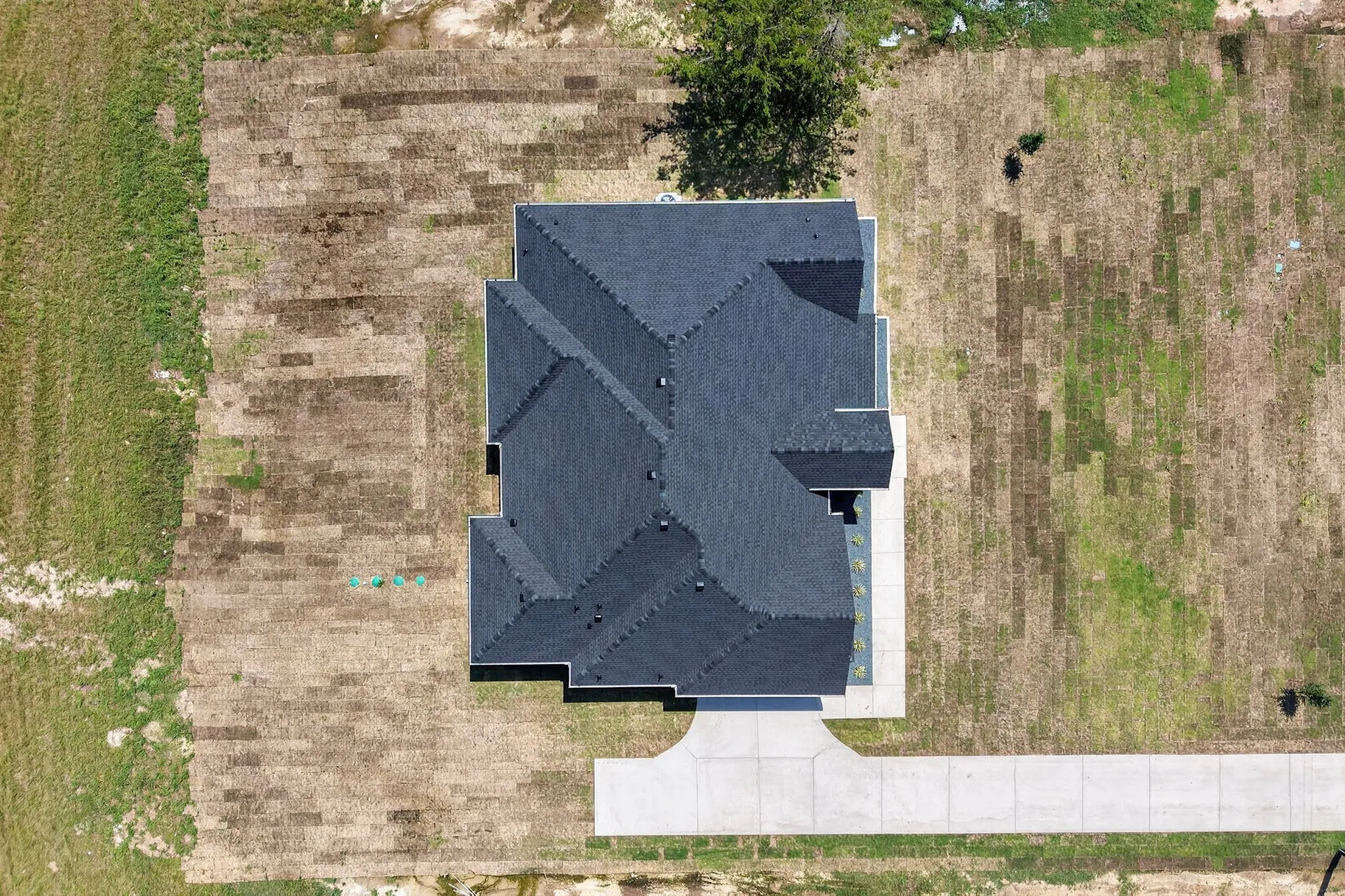 Newly constructed residence featuring a dark gray shingle roof with multiple gables