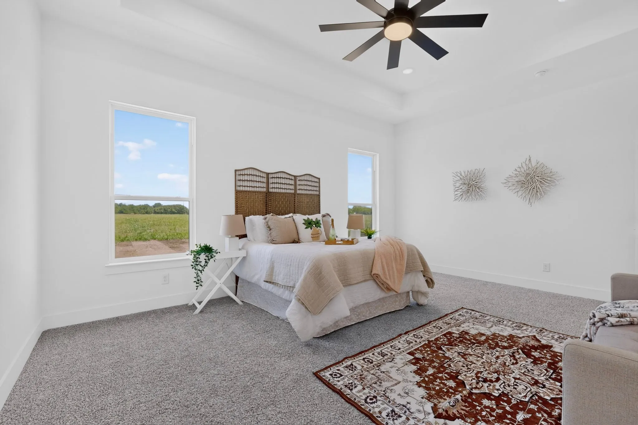 Bright room featuring two large windows, white walls, tray ceiling, recessed lighting, and a modern ceiling fan