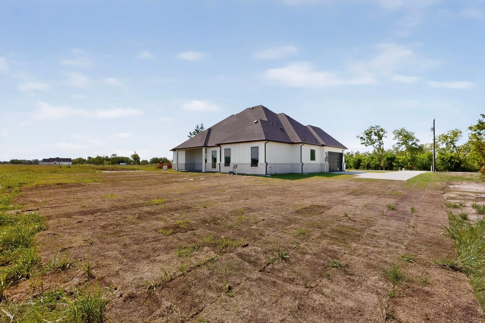 Newly constructed residence featuring a white exterior with a dark roof