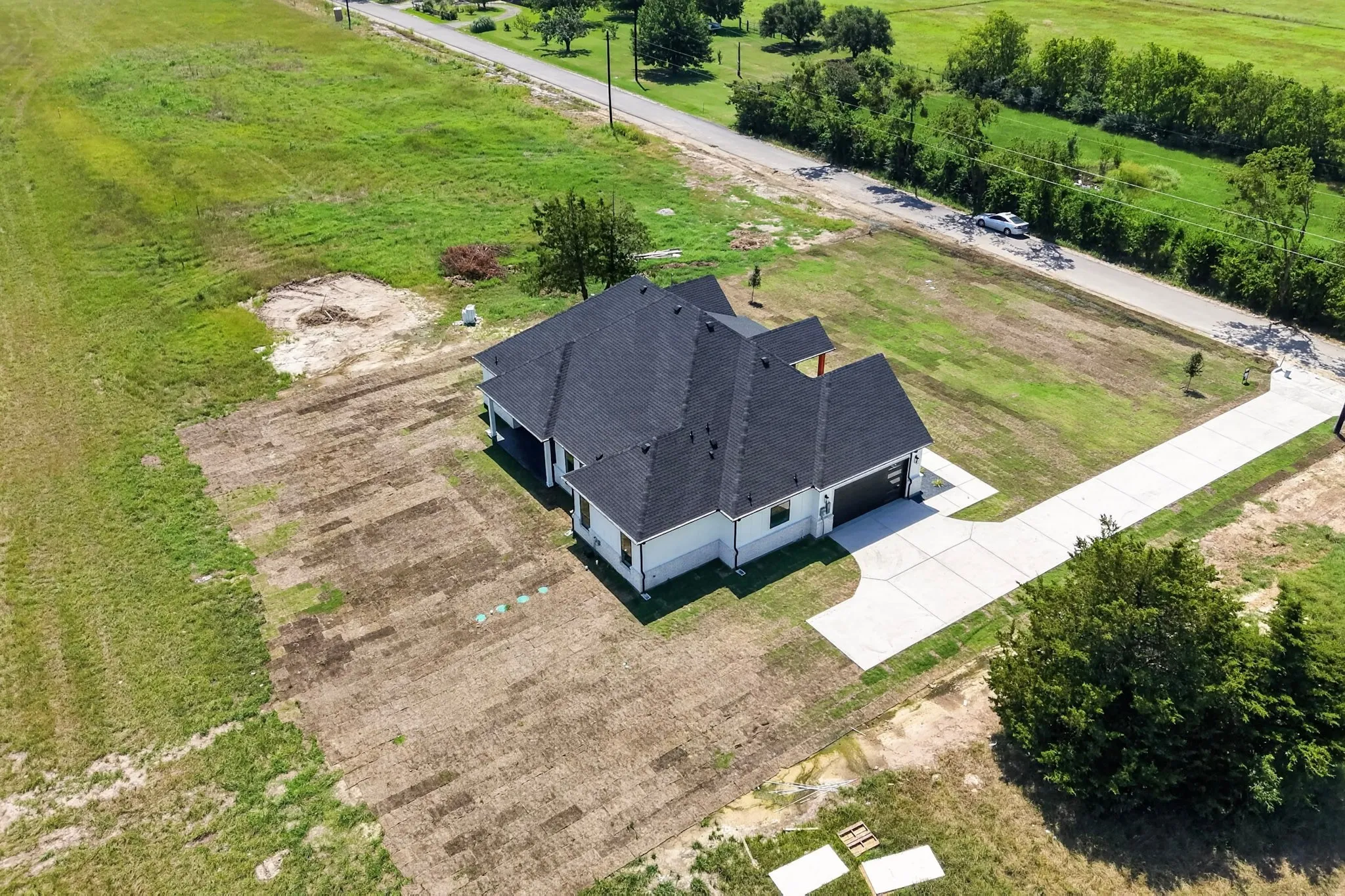 New construction residence featuring a dark shingle roof and light-colored siding