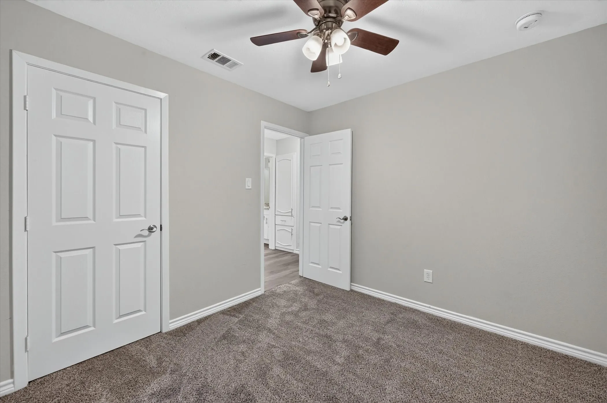 Bedroom featuring plush carpet flooring, light grey wall paint, and crisp white trim