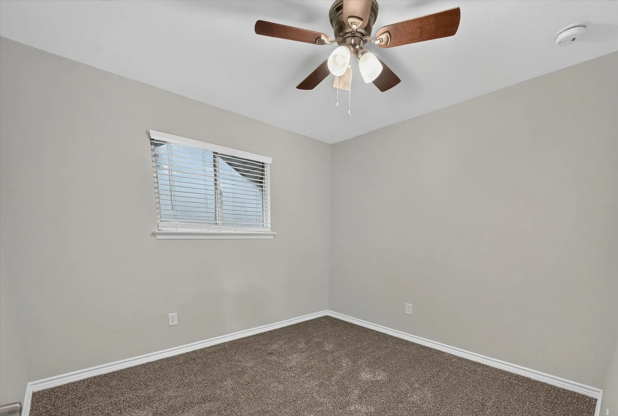 Neutral-toned walls complement the brown textured carpeting