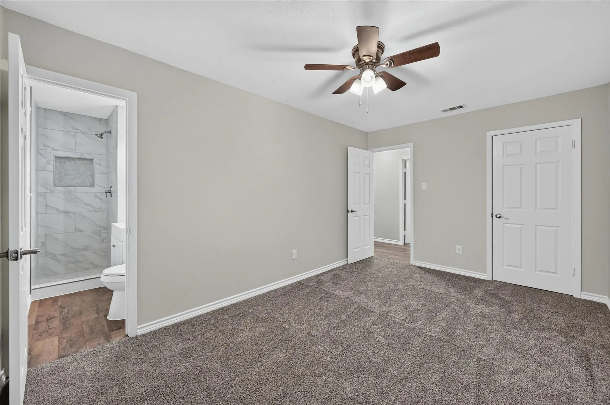 Spacious room featuring gray carpet flooring and neutral wall tones