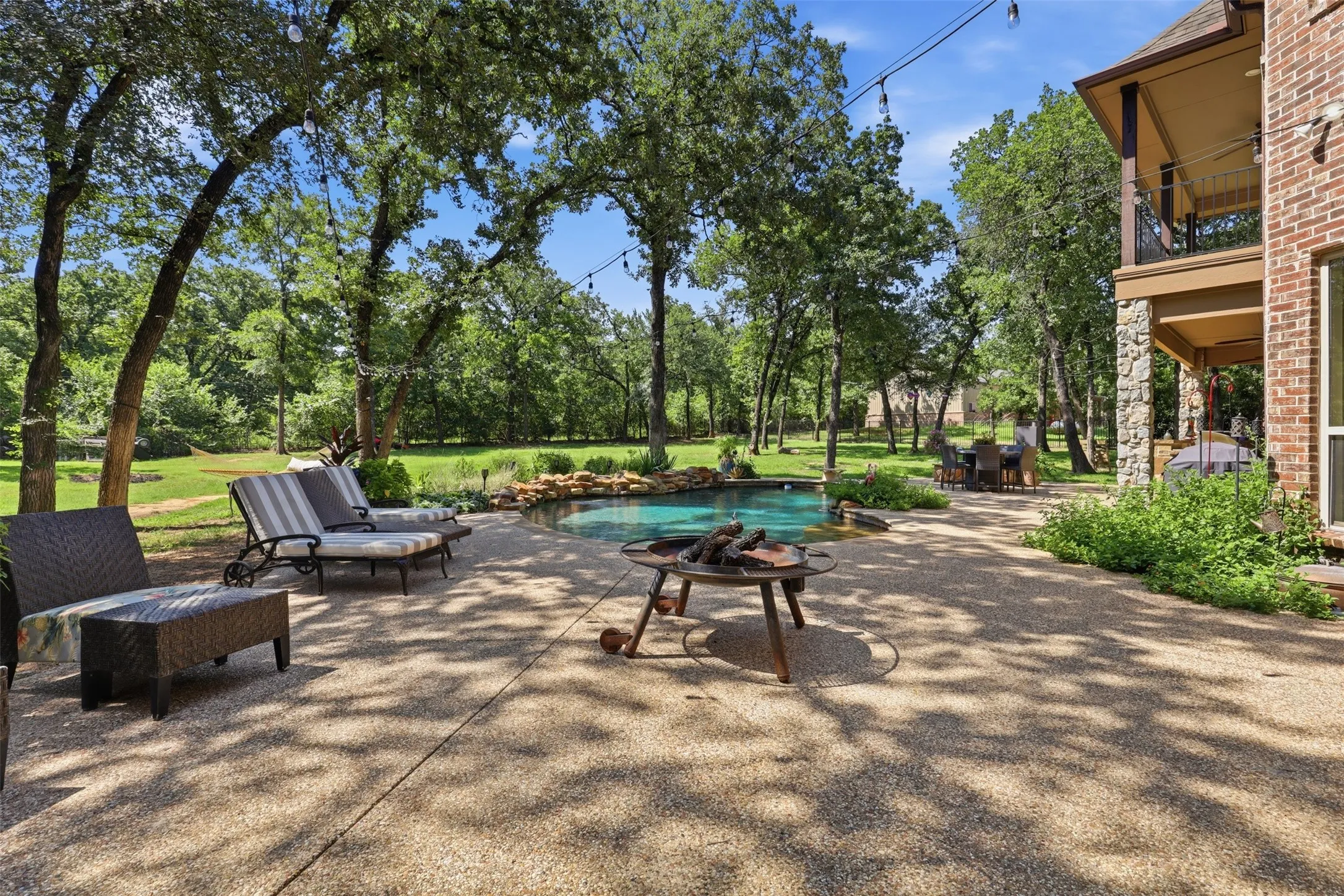 Expansive backyard featuring a large swimming pool with rock detailing