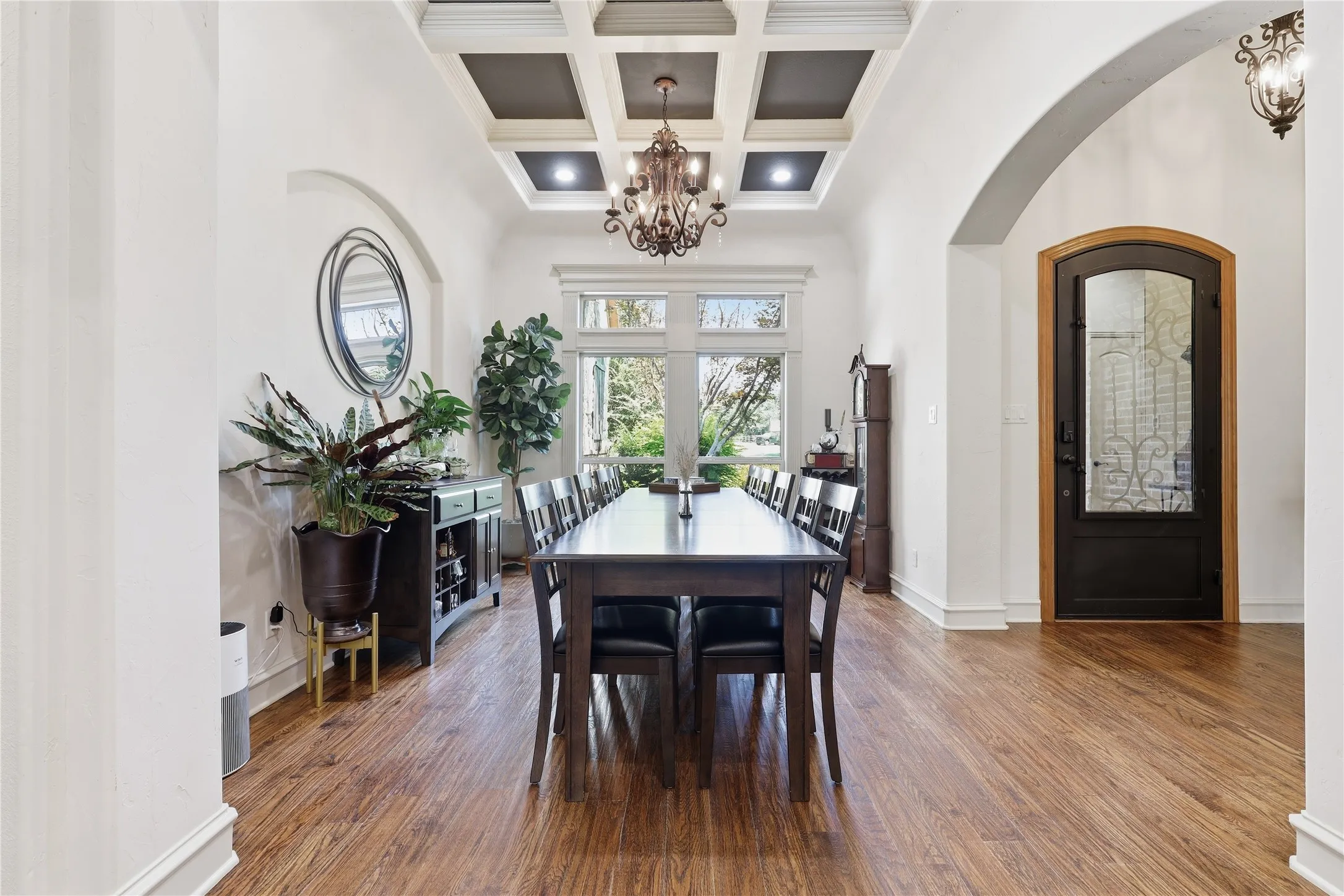 Dining space featuring a coffered ceiling, wood-finish flooring, and a large window