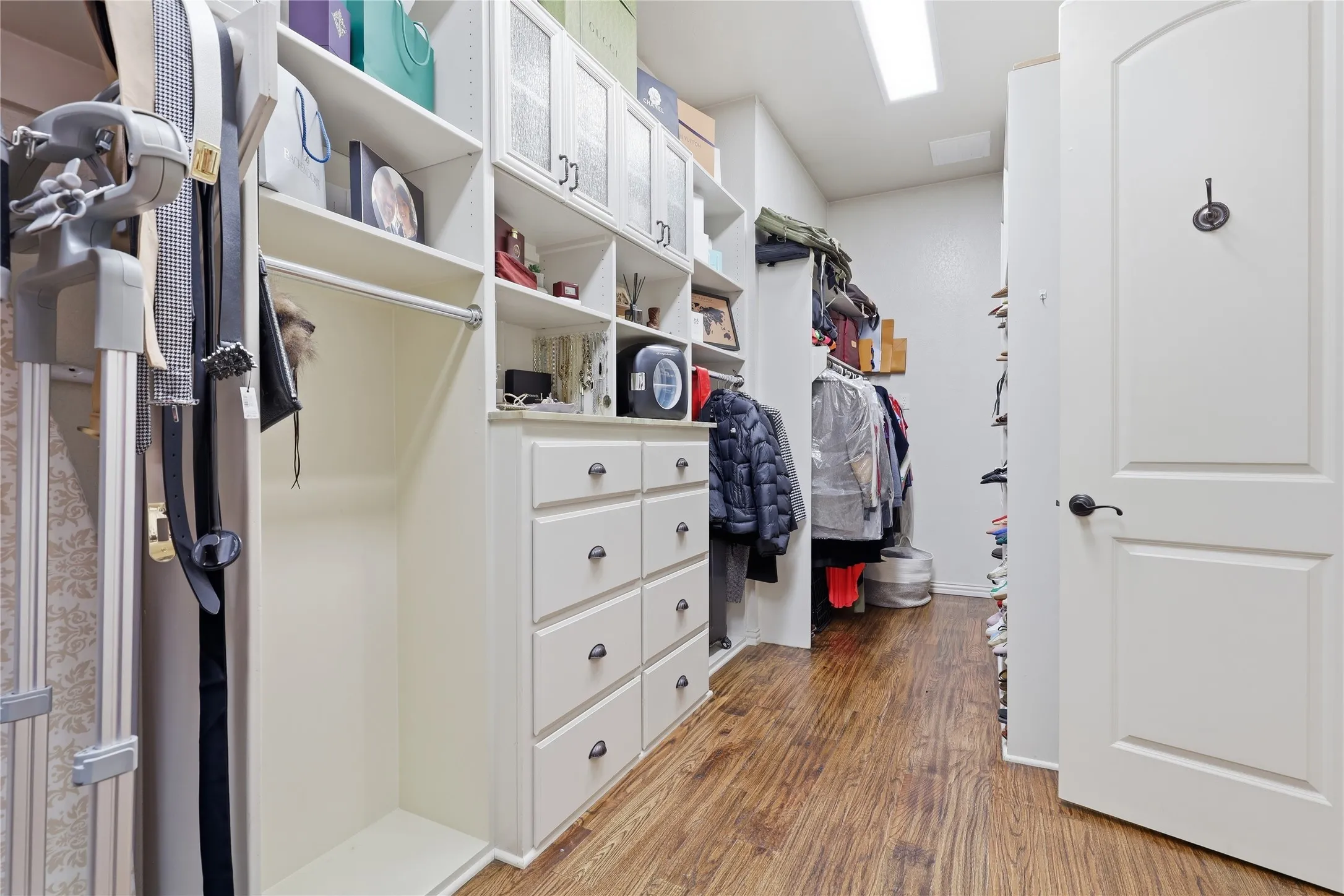 One of the primary Walk-in closets, with extensive custom built-in shelving, drawers, and hanging rods