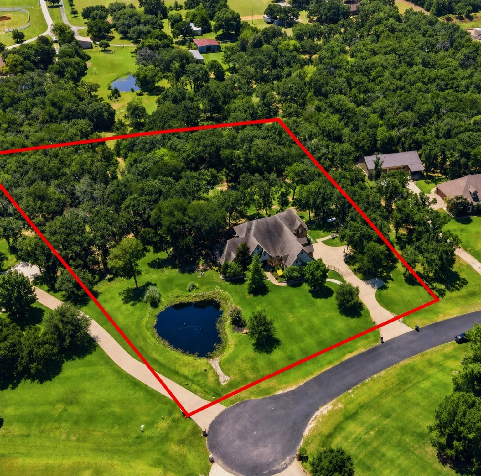 Expansive property featuring a mature treed landscape, a private pond, and a large dwelling with a multi-gabled roofline