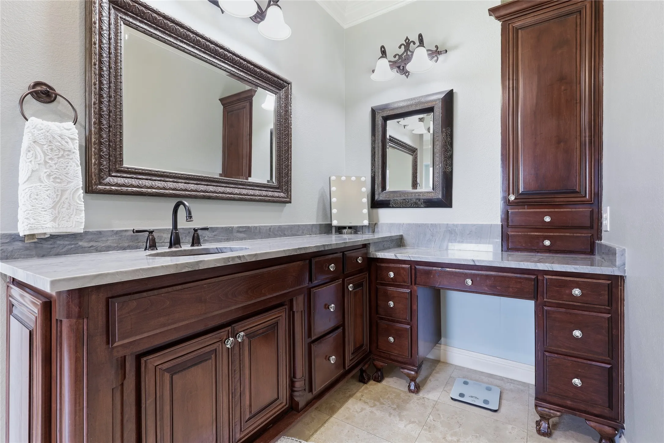 Bathroom vanity featuring a dark wood finish, a light-colored countertop, and an undermount sink with a black faucet