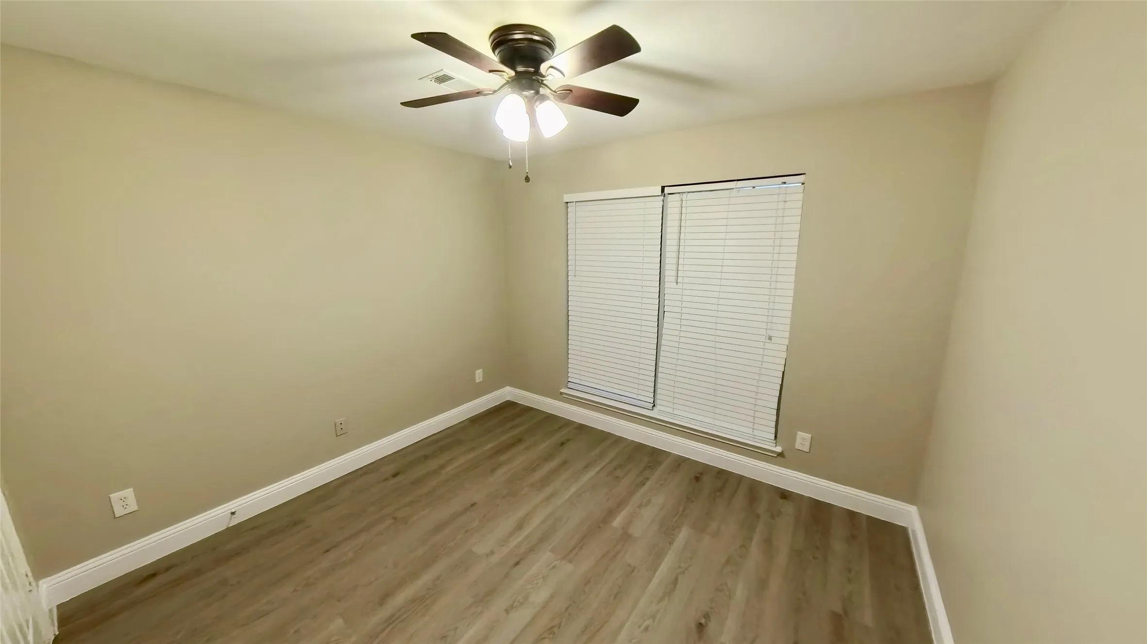 Unfurnished bedroom with ceiling fan and light hardwood / wood-style flooring