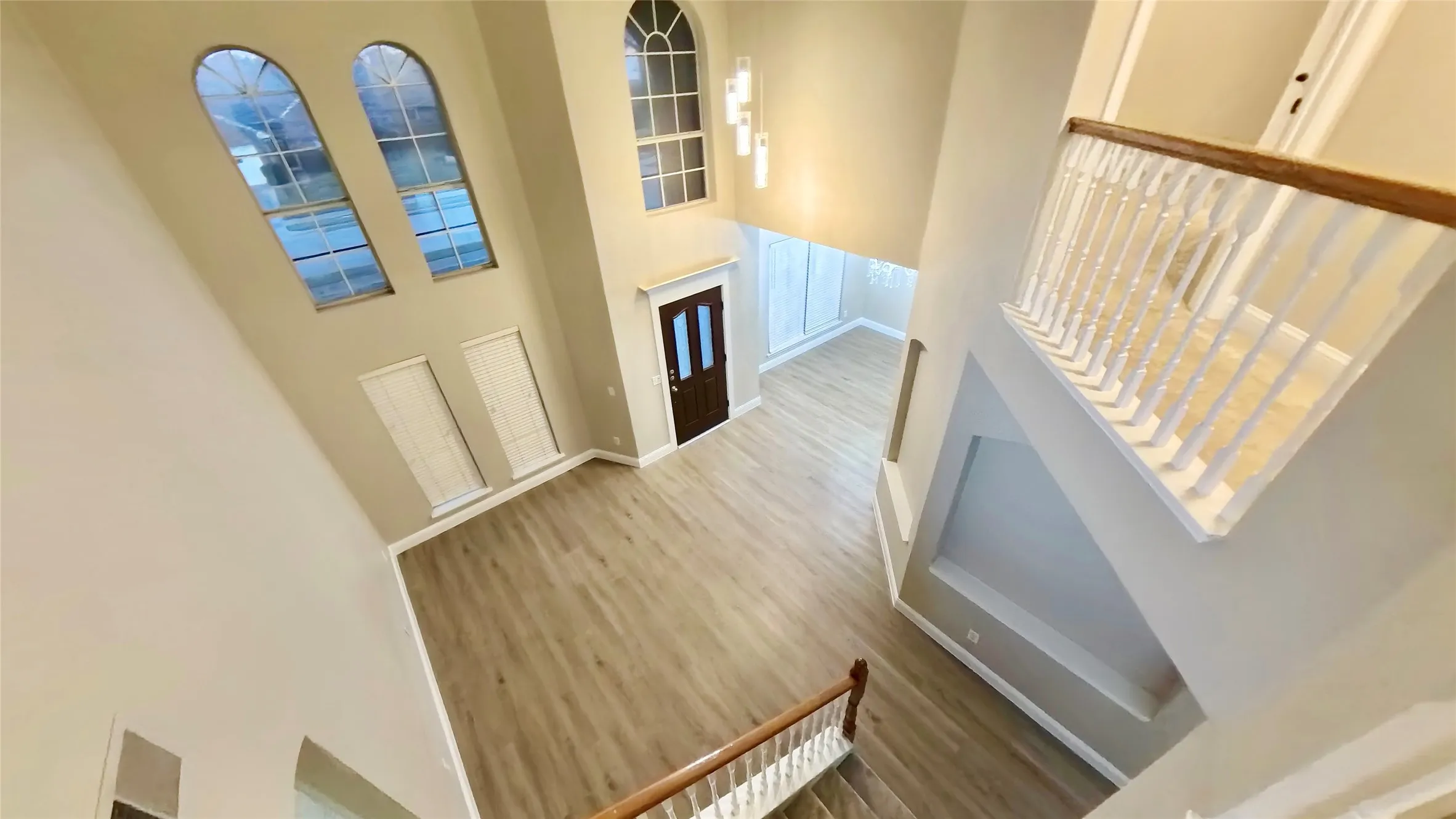 Foyer with hardwood / wood-style floors and a towering ceiling