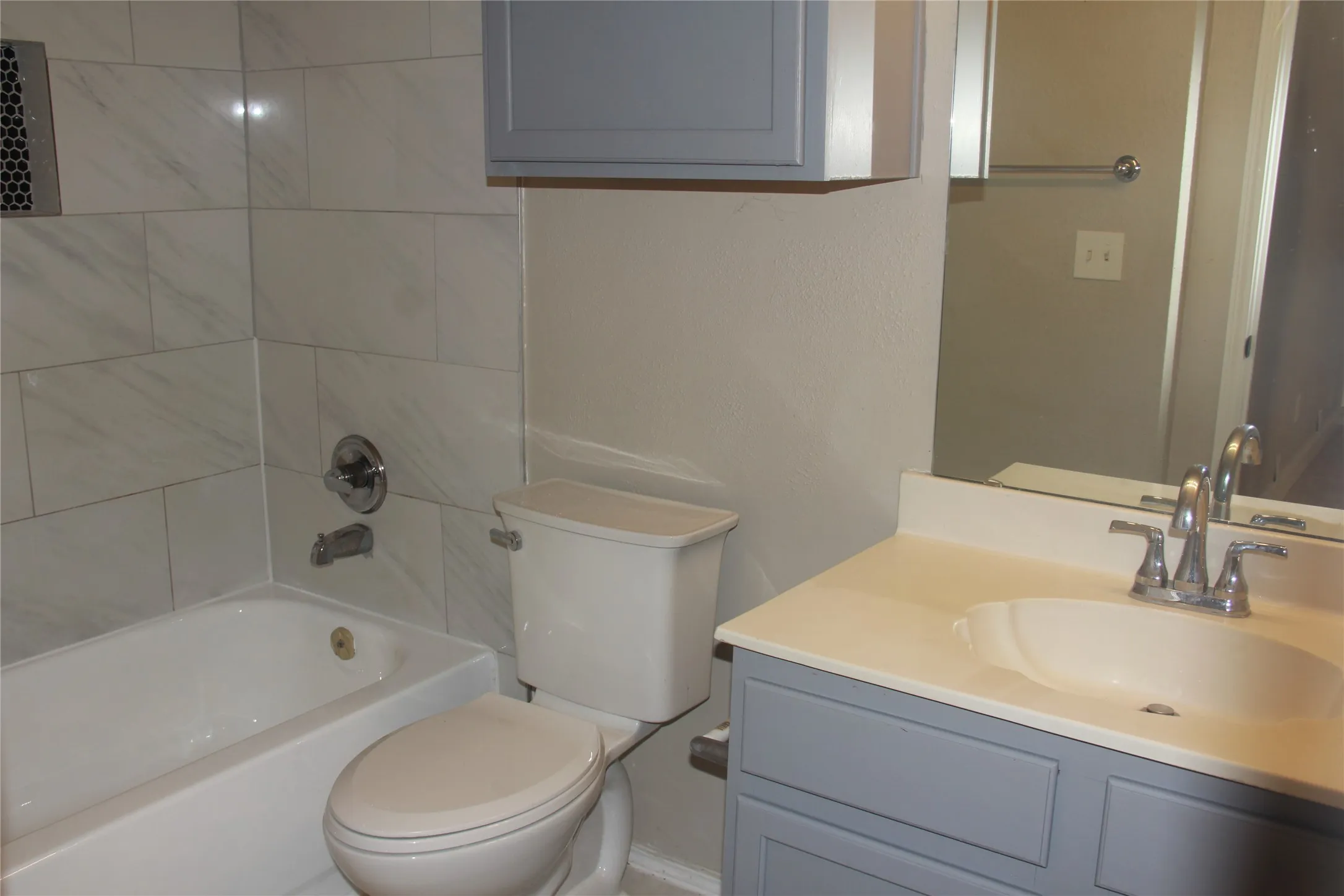 Full bathroom featuring vanity, toilet, and tiled shower / bath