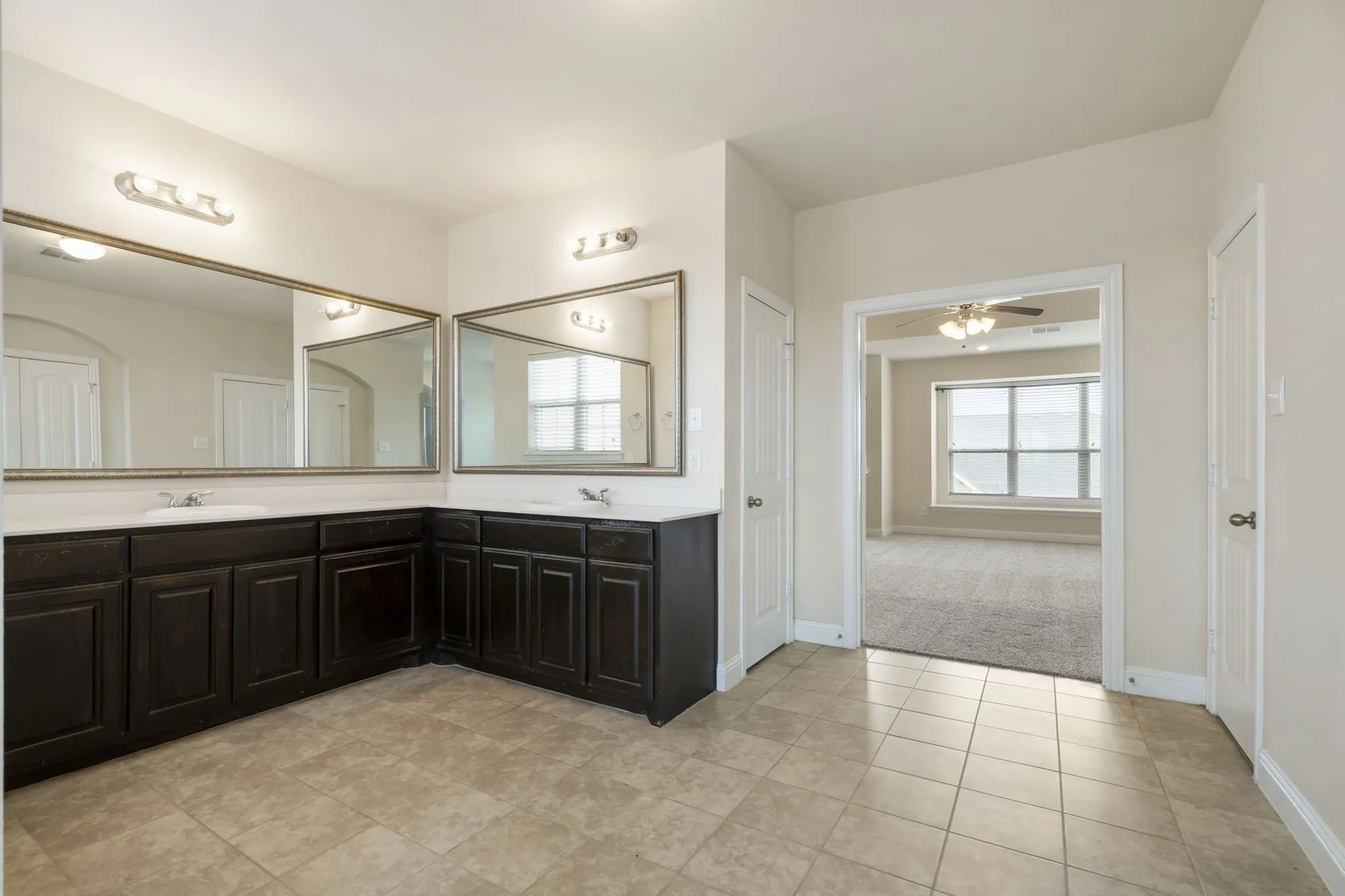 The expansive counter has two sink and vanity areas and abundant lighting.