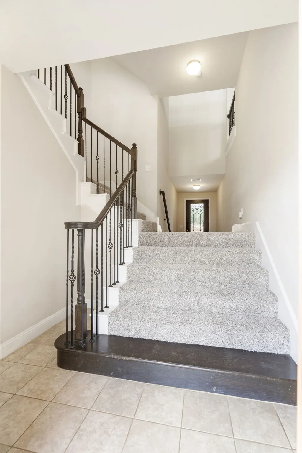 The "back" side of the first floor stairs. There is a storage closet, laundry room, garage access and bedroom with it's own private bath on this side of the stairs.