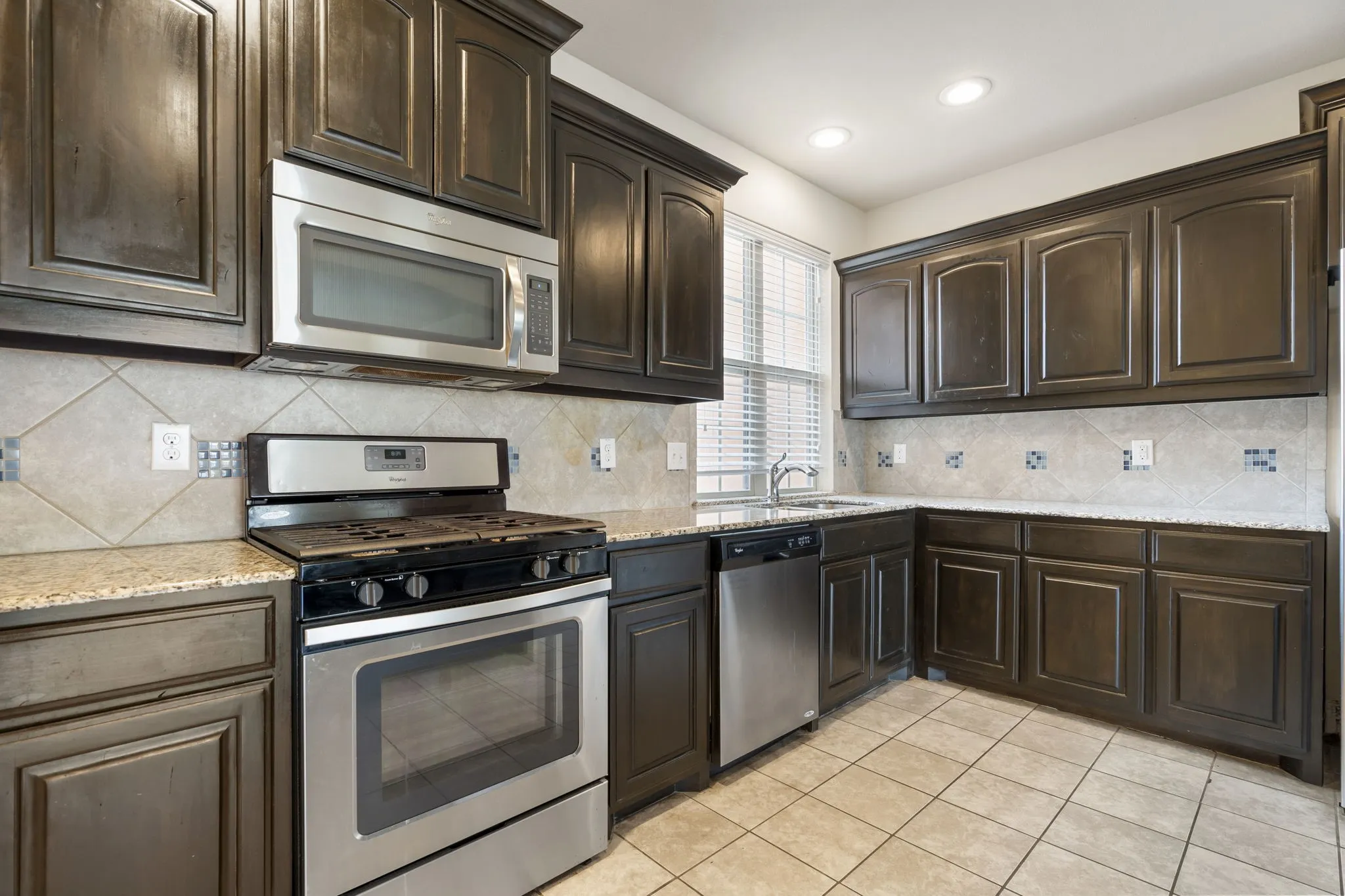 The kitchen has ample storage, counter space, and a gas cooking range.