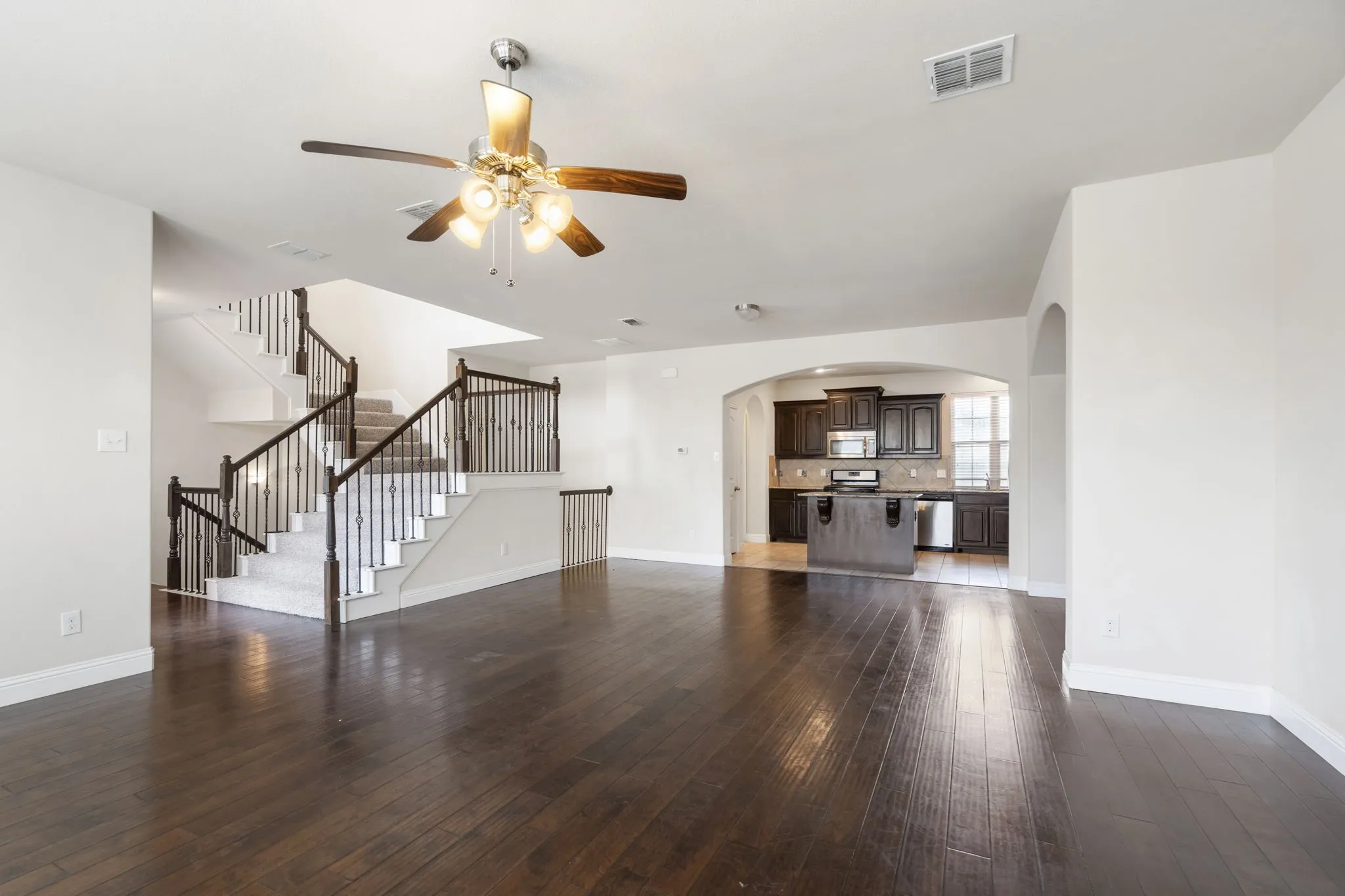 A view of the Great Room showing how open the floorplan is from living to dining to kitchen.