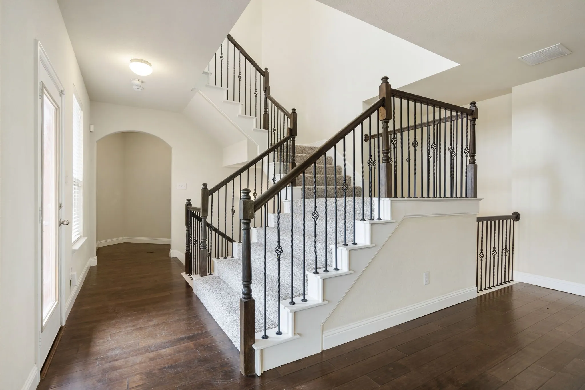 From the second floor hallway, you can see the office nook area through the back arch...then up to the primary suite!