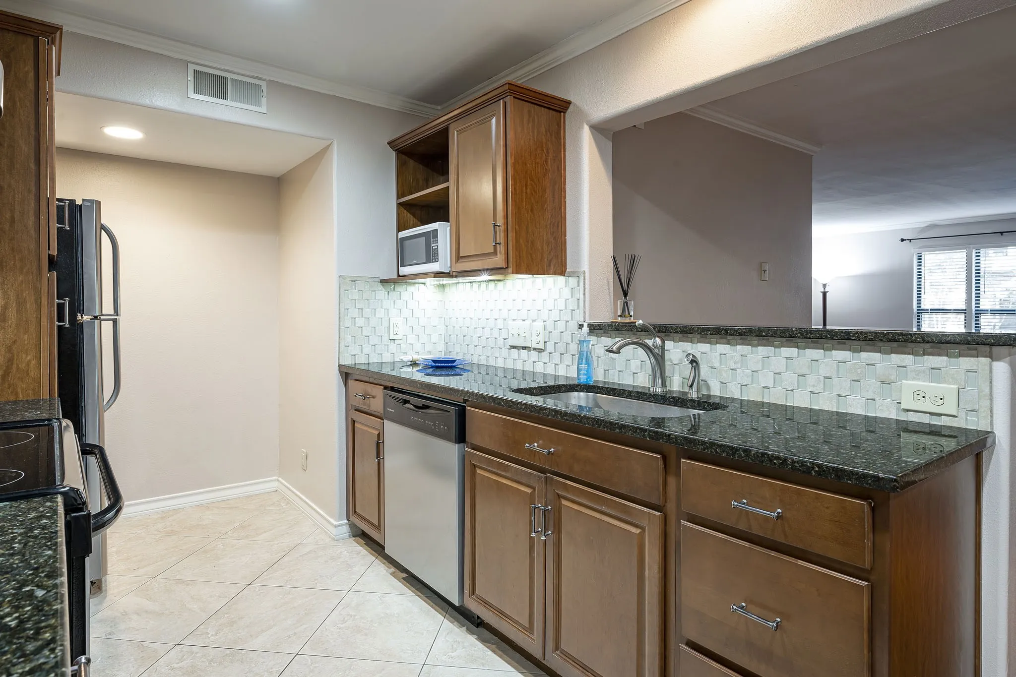 Beautiful open kitchen design which granite countertops, stainless appliances, recessed lighting, stainless sink, and full-size washer dryer