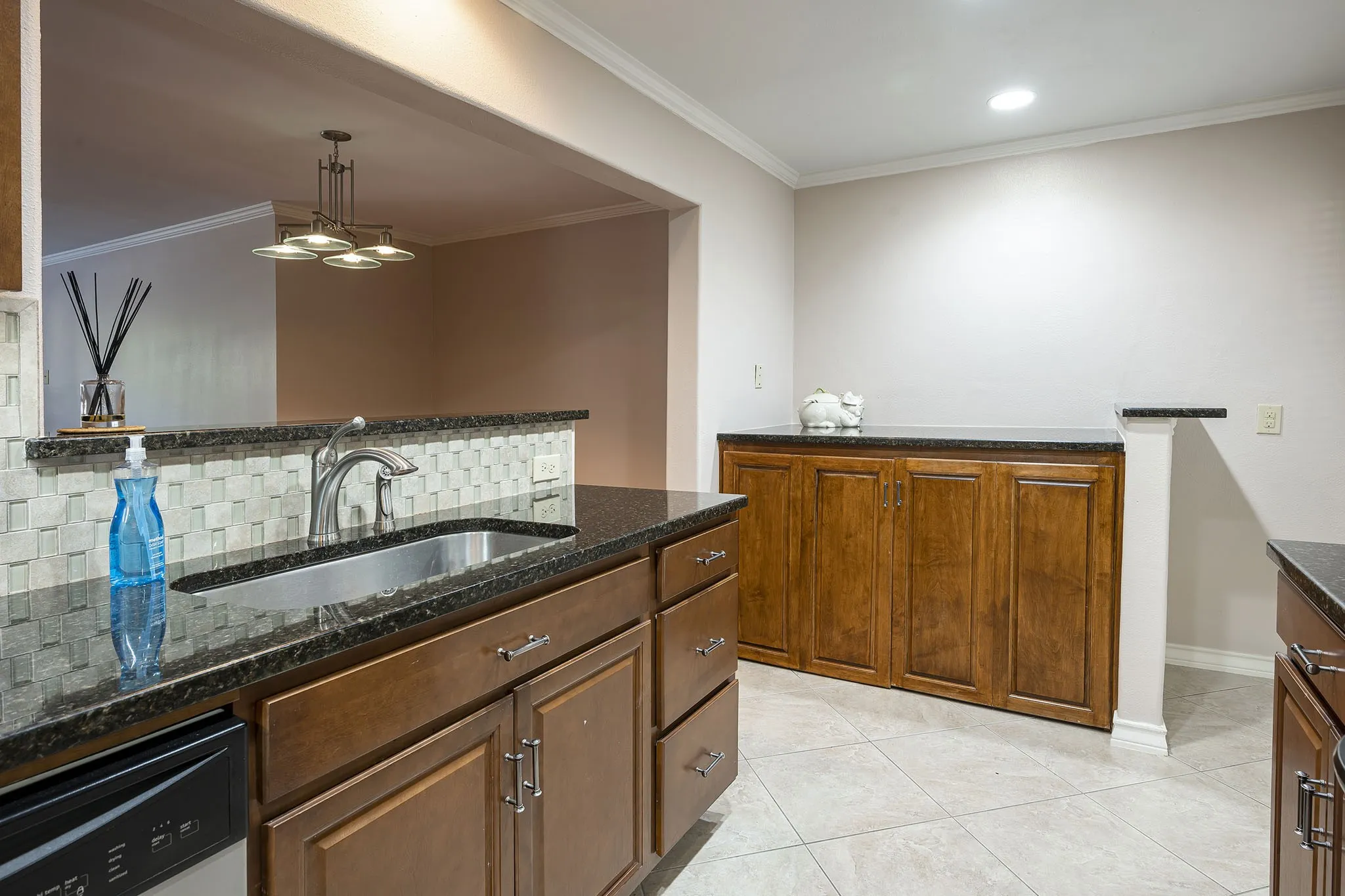 Full size washer and dryer are hidden in custom cabinet enclosure with additional granite counter space on top
