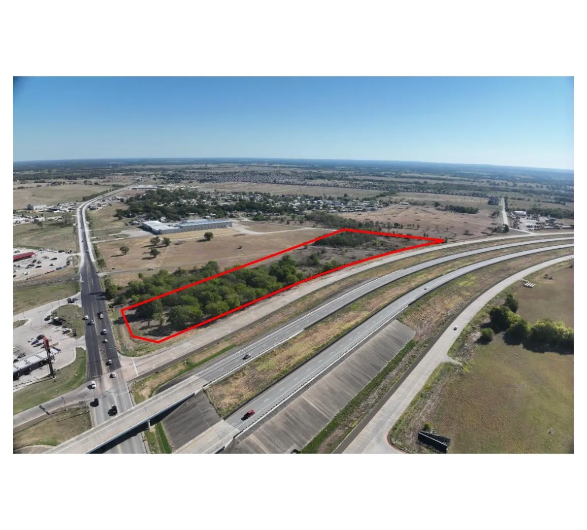 Expansive land parcel featuring highway frontage, significant road accessibility, and mature tree coverage