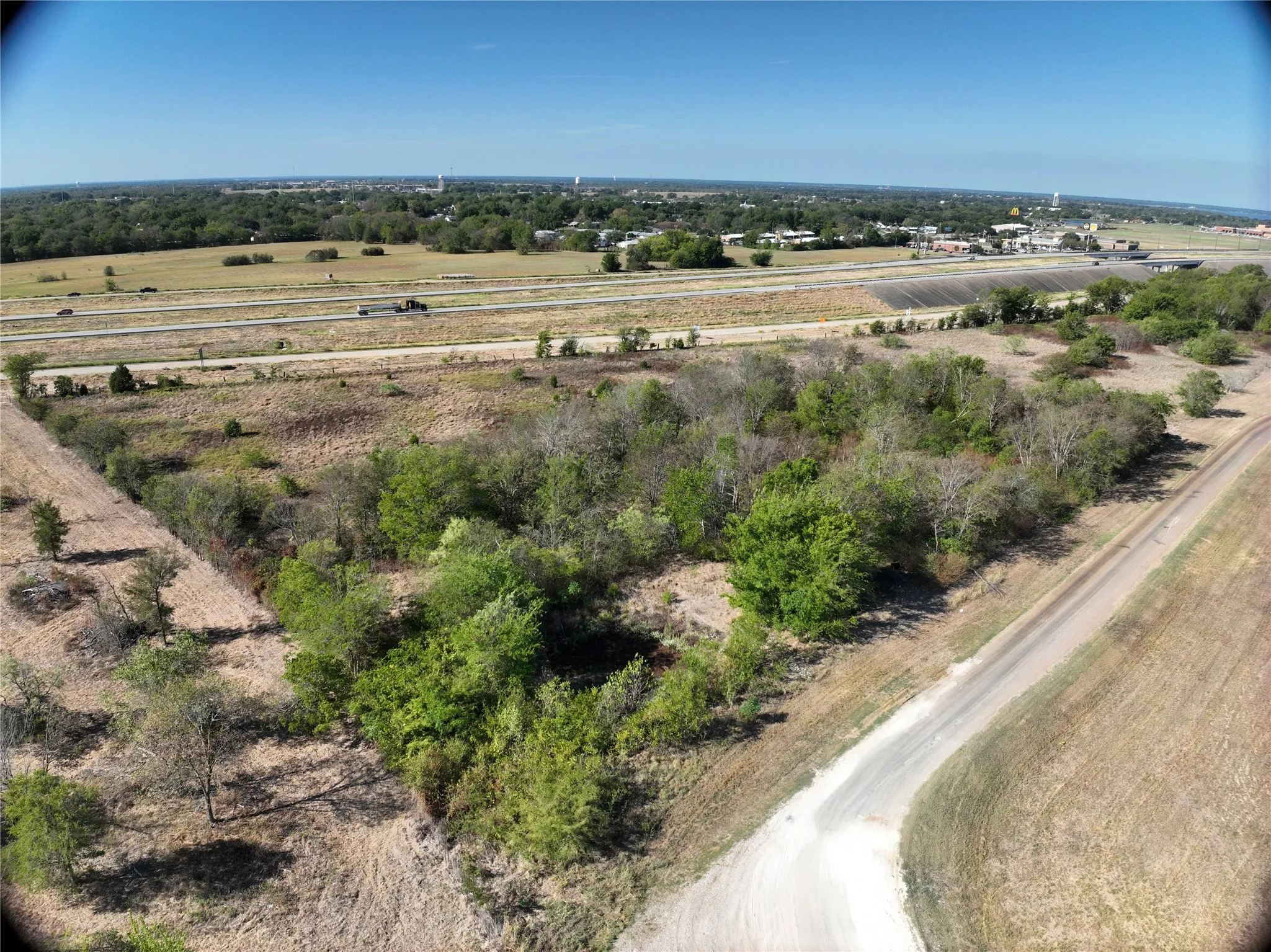 Expansive undeveloped land featuring natural vegetation and direct access to a paved road