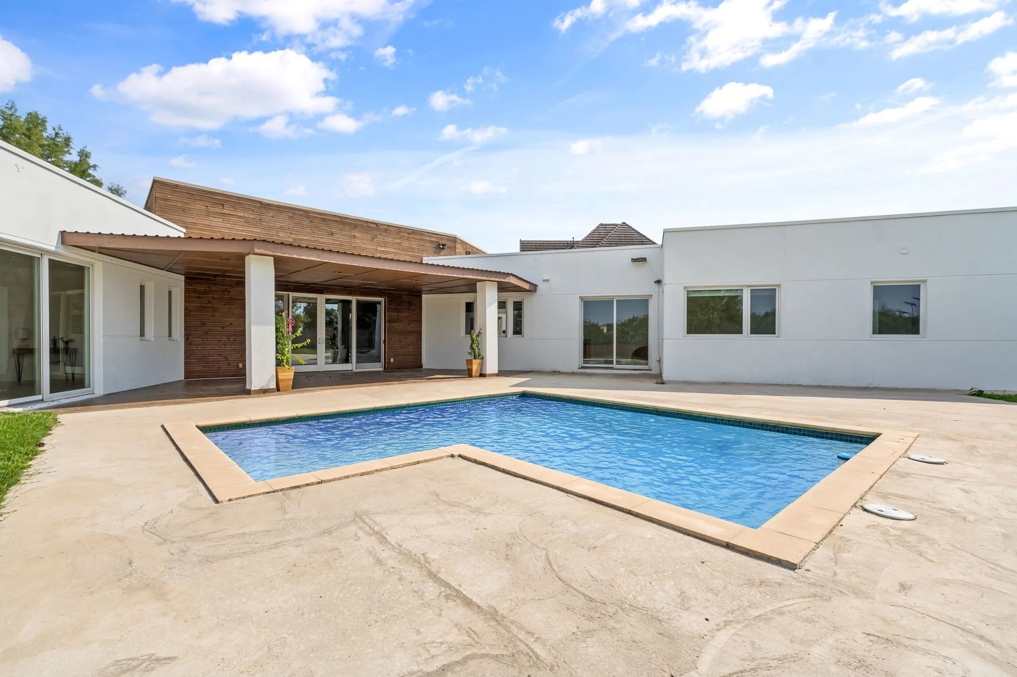 Exterior pool area featuring a perimeter concrete patio and a rectangular swimming pool with light-colored coping