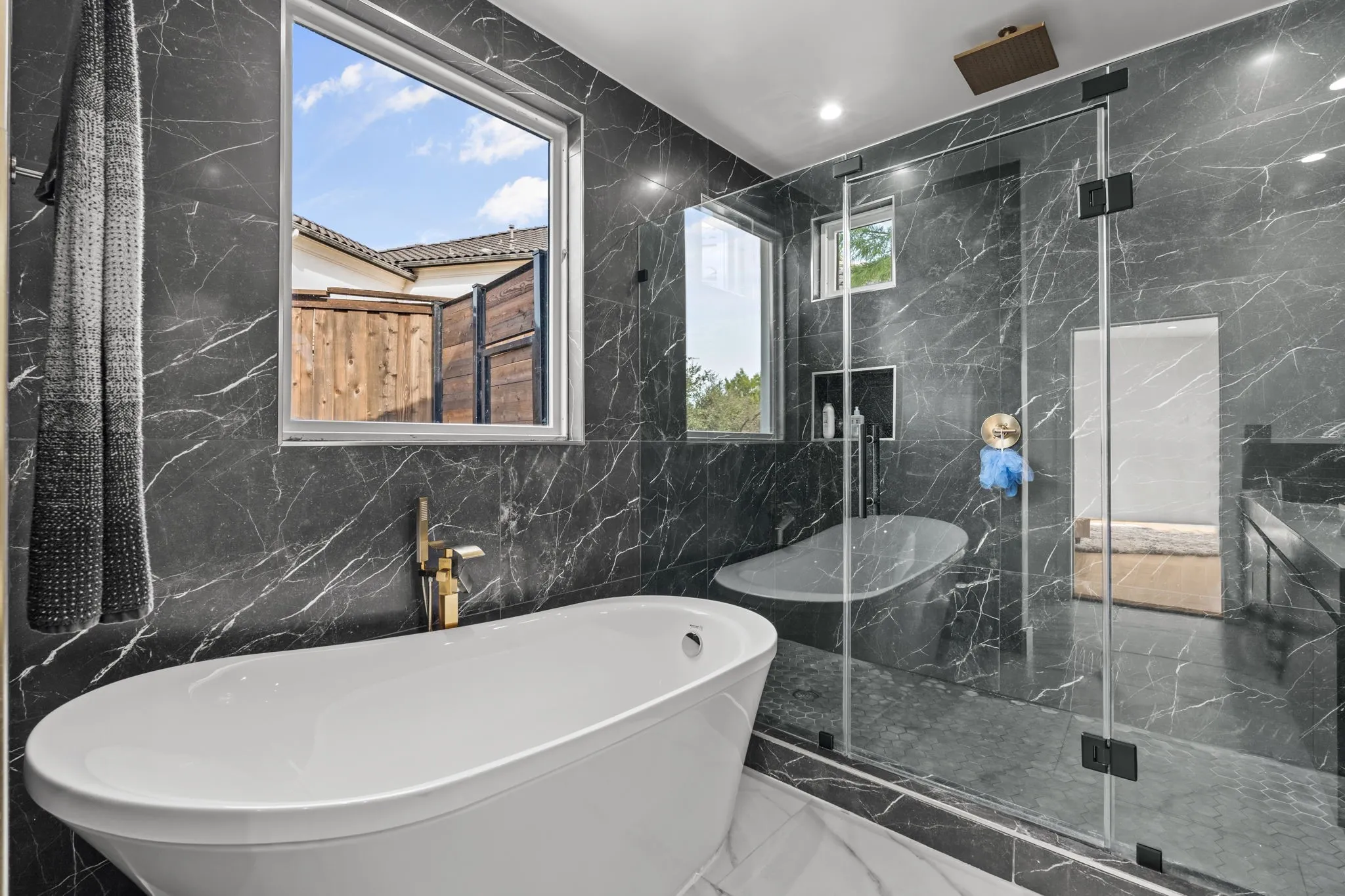 Primary bathroom with Freestanding soaking tub with gold-finish fixtures