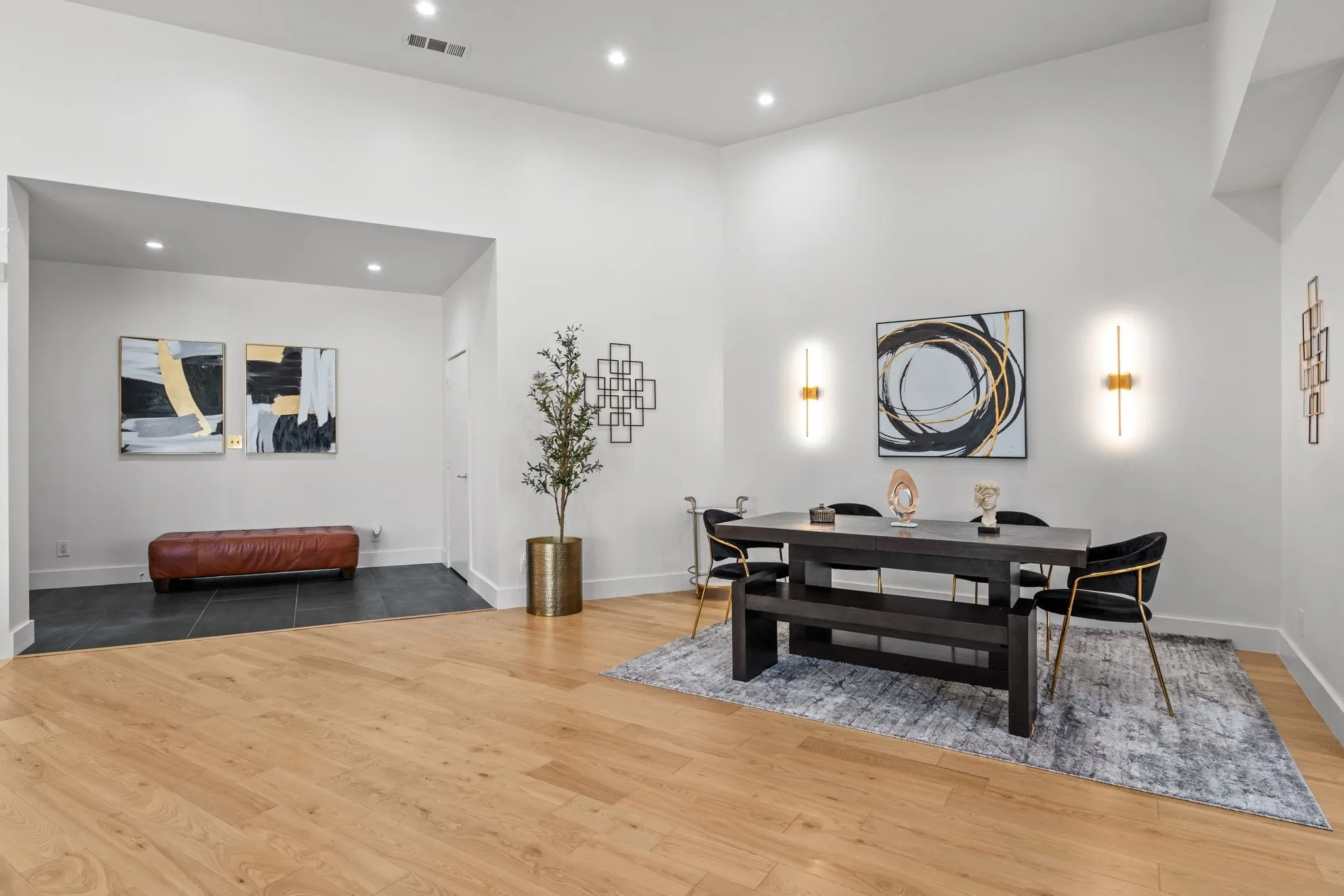 Bright open-concept space featuring vaulted ceilings, recessed lighting, wood-finish flooring, and a distinct tiled entry area