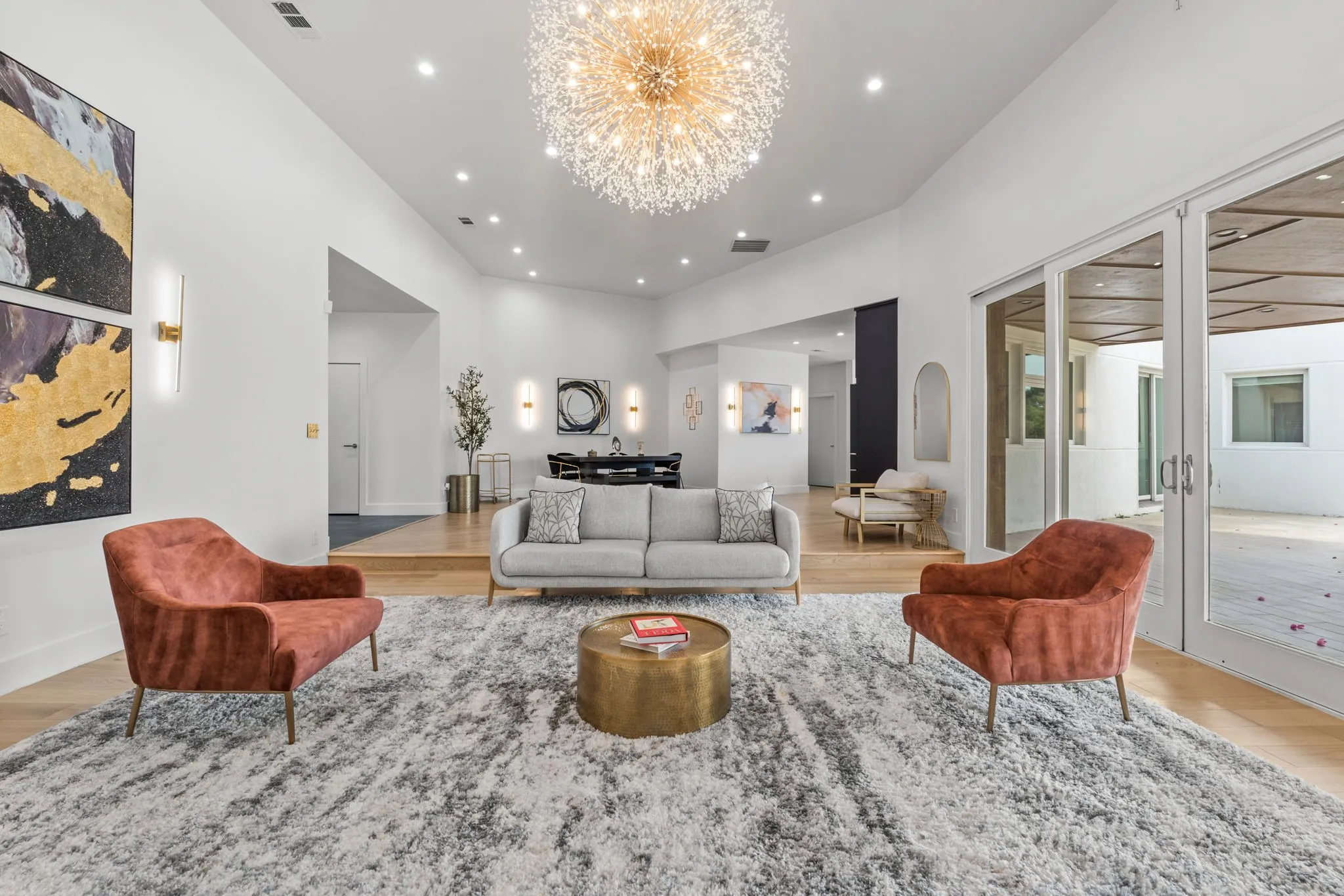Spacious living area featuring a vaulted ceiling with recessed lighting and a contemporary crystal chandelier