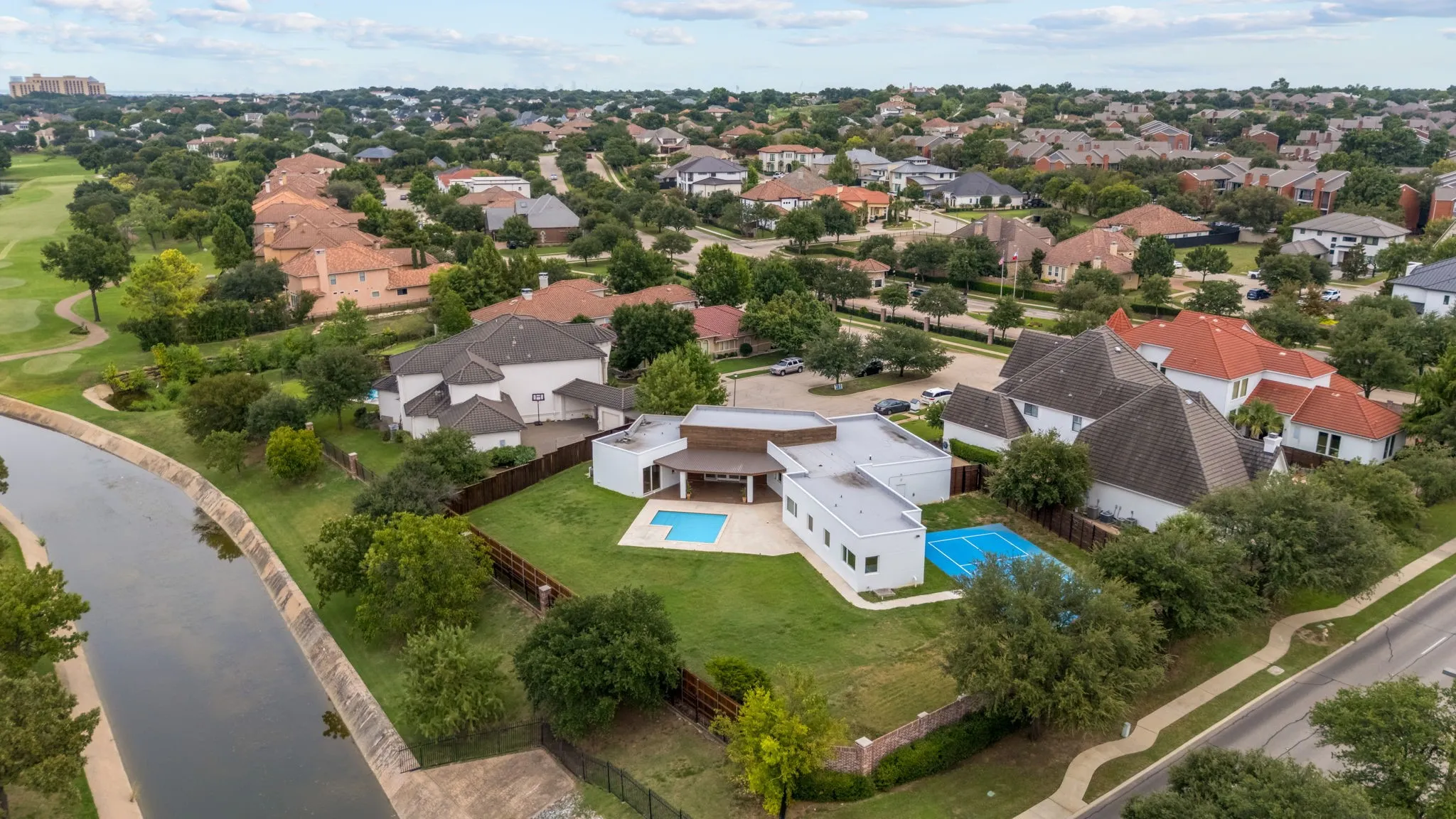 Contemporary residence featuring a private swimming pool, sports court, and an expansive lawn